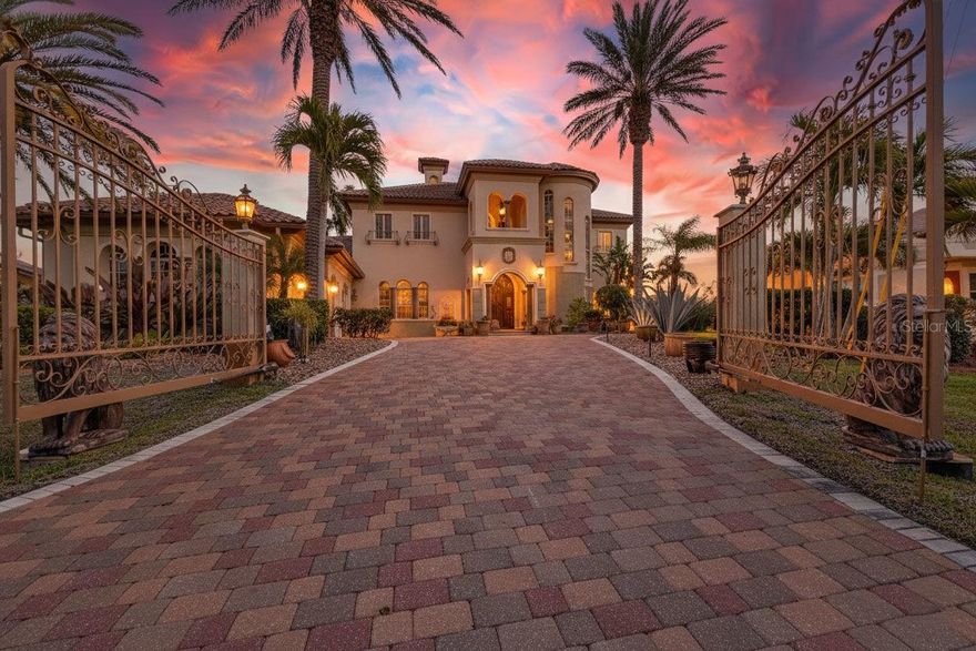 Welcome to exceptional waterfront living in the desirable South Gulf Cove community, positioned on a tip lot with an impressive 160 feet of intersecting canal frontage. This Mediterranean-style residence offers 4 bedrooms, 5 bathrooms, and a 3-car garage behind a remote-controlled iron gate, where a granite-floored portico and a striking 12-foot Brazilian wood arched entry door create a memorable first impression. Inside, a grand foyer showcases granite and marble flooring, crown molding, plantation shutters, and multi-level coffered ceilings accented by dramatic chandeliers. A sweeping Travertine marble circular staircase leads to an upstairs ensuite guest room with private balcony, a guest bath, and two additional guest rooms, one also featuring its own balcony. Located on the main level, the primary suite serves as a private retreat with a wet bar and beverage refrigerator, dual walk-in closets, and an ensuite bath with dual sinks, a tiled shower, and a Jacuzzi spa, while French doors open to the lanai, filling the space with natural light and water views. Canal views take center stage in the formal living room, with a French door to the lanai and a fireplace crafted from Macedonian stone. Mahogany doors open to an additional room with lanai access, ideal for guests or a home office. Designed as a true centerpiece for entertaining, the chef’s kitchen includes granite countertops, a large breakfast bar, a center island with storage, Viking appliances including a gas stove, double oven, warming drawer, full size wine refrigerator, ice maker, trash compactor, and a walk-in butler’s pantry with additional storage and a full-size refrigerator, complemented by both a casual dining nook and a formal dining room. Creating a natural connection between indoor and outdoor spaces, the family room opens directly to the lanai and pool area, where an expansive paver brick lanai invites relaxed afternoons and elegant evenings, offering multiple seating and lounging areas, a heated salt water pool and spa resurfaced in 2025, a pool bath, and sweeping panoramic views of intersecting canals. Overlooking the water, a Trex dock is equipped with both 16,000 and 10,000-pound boat lifts. From the private dock, spend leisurely afternoons cruising the winding canals or set out for full days on the water with direct access to the Gulf. Impact windows, a new roof installed in 2023, exterior paint completed the same year, two updated HVAC systems replaced in 2020 and 2025, a new washer and dryer installed in 2024, and a pool pump and heater replaced in 2025, provide added peace of mind. Conveniently located near dining, shopping, and entertainment, with easy access to Englewood Beach as well as Sarasota and Fort Myers, this exceptional waterfront estate offers a rare combination of architectural presence, expansive waterfrontage, and a private boating lifestyle designed for those who value both craftsmanship and setting.
