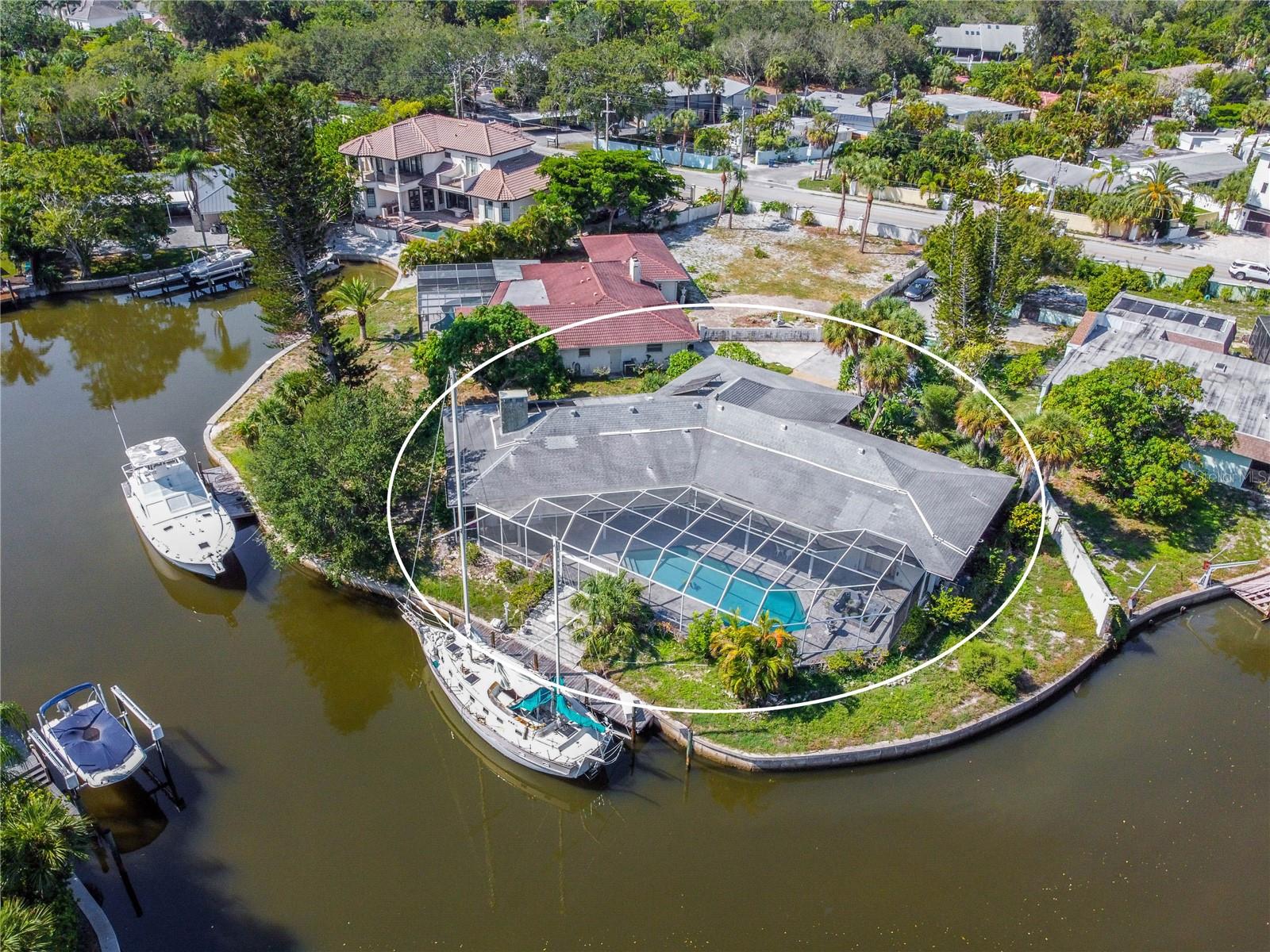 Location, location, location! Talk about a rare opportunity on Siesta Key, situated on a private .41-acre canal-front lot, the property offers a boat dock and 234 feet of sailboat capable concrete seawall with direct access to the intracoastal waterway. Relish a tranquil waterfront lifestyle in this nearly 3,000-square-foot pool home on Siesta Key, just a short stroll to Crescent Beach's pristine white sands on the Gulf of Mexico and close to dining and shopping. Tile flooring flows throughout the main living areas of the 4-bedroom, 3-bathroom home, which features spacious indoor-outdoor living spaces. The expansive kitchen offers abundant cabinetry and countertops and is adjacent to the family room, featuring a fireplace and a wall of sliding glass doors to the screened paver lanai with a pool and serene views of the water and surrounding tropical scenery. A new roof was completed in April, 2024. The home is just 2 miles to world-renowned Siesta Key Beach and a half-mile to Stickney Point Road, which provides easy access to the mainland's wide selection of restaurants and shopping. Don't miss this wonderful opportunity to either renovate and make this house your own or start fresh and build your waterfront dream home.