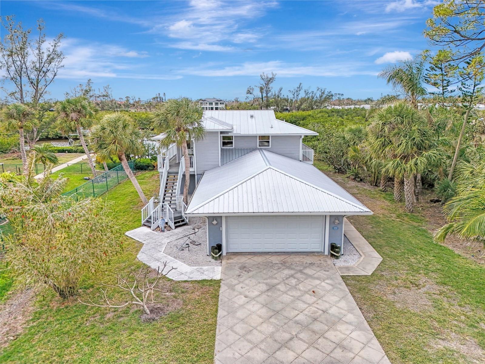 Welcome to this charming waterfront coastal cottage, offering stunning views of Gottfried Creek and the surrounding mangroves, and capturing the essence of nostalgic 'Old Florida' living. Delight in breathtaking sunsets and endless stargazing from your private 8500 lb boat lift(additional deposit required), with direct access to Lemon Bay and the Gulf of Mexico just minutes away. Perfect for kayaking, birding, and fishing, this home beautifully blends outdoor beauty with cozy, light-filled interiors. The open floor plan features a kitchen with a 'Boos Block' butcher block countertop, seamlessly flowing into the main living area with plantation shutters. Sliding doors lead to a spacious 1000 sq. ft. screened lanai, a second-floor deck, and a paver sun patio, all overlooking the serene creek. The primary bedroom, conveniently located off the main living area, boasts a walk-in closet and lanai access, with a nearby bathroom featuring dual sinks and a walk-in shower. Downstairs, you’ll find a laundry room, office/den, guest bedroom, and additional bathroom. The 860 sq. ft. air-conditioned garage is a hobbyist’s dream, offering ample storage, epoxy floors, and workshop space. Safety and efficiency are paramount throughout the home, with a metal roof, newer gutters and soffits, hurricane shutters, an internet-controlled thermostat, a Schlage smart front door lock, a 5-camera security system with DVR, and a Sony amp with six hard-wired speakers. In 2024, the seller upgraded the first story of the home by removing drywall and installing composite Endura Flood panels. The exterior impresses with a 240 sq. ft. storage shed, outdoor shower, hot tub, additional half-bath, separate fish cleaning hut with boat gear storage, sun patio, fire pit, and a freight elevator. Zoned for up to 5 units an acre, there’s potential to add a guest cottage. Located just 2.5 miles from Englewood Beach, this home offers easy access to the Intracoastal Waterway, shopping, dining, and more. This property is available as a Seasonal or Annual rental. Seasonal rent $4500/mo plus tax and fees and Annual $3900/mo.