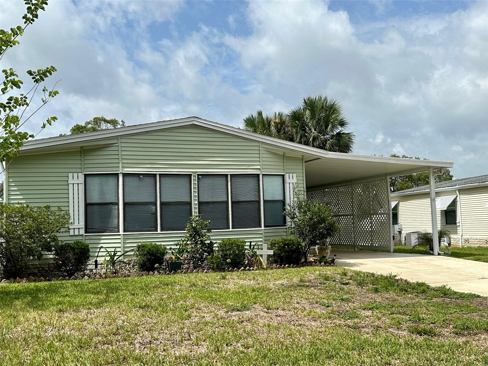 Under contract-accepting backup offers. Charming two bedroom and two bath home located on North Citrus Circle in Zellwood Station. Key features include: Shingle Roof (2018) & AC (2019) and PEX plumbing. In addition to laminate floors throughout and vaulted ceilings. This home has an interior laundry off of the hallway for convenience, an open concept floor plan ideal for entertaining family and guests plus a screened Florida room. The driveway is extra long, plenty of room for cars or your golf cart to park. This home includes a storage unit under the carport near the screened porch for additional storage. Guest bedroom closet is 11x2 and Master bedroom closet is 12x3. Measurements and timelines approximate. Co op ownership. 55+ resident owned, golf and gated community. 72-par golf course, on-site restaurant and too many amenities to list! Easy access to 429 for travel to Orlando and local attractions.