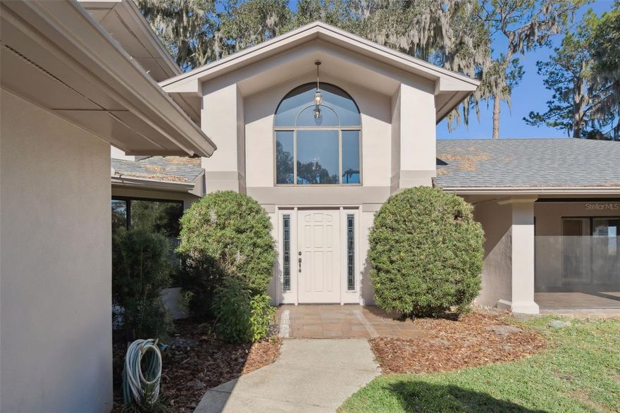 You are going to love this LAKE VIEW, not to mention the SUNSETS! This stately 3230' home sits on 164' of LAKE DORA shoreline. Lake Dora is a 4,500-acre lake, one of the seven lakes of the Harris CHAIN OF LAKES, known for fishing and recreational boating. The DORA CANAL connects Lake Dora to Lake Eustis to the north and Lake Dora is connected to Lake Apopka to the south by way of Lake Beauclair and the Apopka-Beauclair Canal. As you enter the home you will notice the custom oak details, oversized staircase, wood burning fireplace flanked by gorgeous, custom bookshelves, built in china cabinets and unique bar. The spacious floorplan complete with formal dining room, great room, breakfast room, lovely kitchen, a mysterious cabinet revealing a hidden, cozy space for storage, two bedrooms connected by a Jack and Jill bath on first floor, primary bedroom with en suite located upstairs large walk in closet, huge bath and an adorable screened balcony perfect for morning coffee. There is no shortage of entertaining spaces, the large lanai measures 31x11 and is completely screened. Three a/c units and a window unit in the garage. The home is designed to capture lake views with numerous doors leading to the screened porches facing the lake. Outdoor shower with hot and cold water. Approx. 70' of decked walkway with new supports lead to the covered, one stall with electric boat lift. There is a workshop space in the garage, the laundry room is conveniently located off the garage with a spiral staircase leading to the primary suite. DEER ISLAND GOLF and COUNTRY CLUB is nearby and opened to the public. NO HOA required for this property! Did I mention the view, it is amazing!