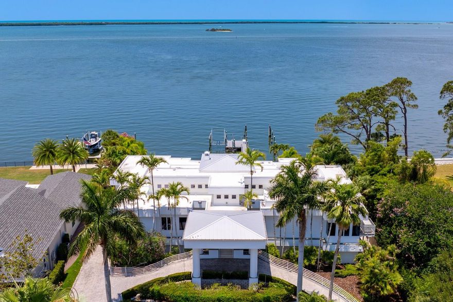 Masterful architectural scale and scope are yours in this stunning contemporary waterfront home offering an unparalleled coastal lifestyle.  Nestled in Dunedin on Santa Barbara Drive, one of the most sought-after streets overlooking the Gulf of Mexico. This tranquil oasis delivers a boating and entertaining slice of waterfront paradise situated on a double lot with a private deep-water dock and multiple slips, lift and dockage for a yacht. From the fully-equipped gym to the state-of-the-art theatre, this legacy home provides the very best of waterfront living in approximately 14,000 total constructed square feet. Step inside and be greeted by a sleek and modern interior adorned with soaring ceilings, floor-to-ceiling windows and expansive retracting doors that flood the living spaces with abundant natural light. Breathtaking vistas, refined finishes, and designer lighting provide the perfect canvas for dramatic coastal luxury at every turn. A grand foyer entry welcomes you to the expansive living room with fireplace, entertaining wet bar and sweeping water views beyond. Beyond the living area is an expansive covered terrace overlooking the water and outdoor entertaining areas. A sleek chef’s kitchen provides top-of-the-line appliances Sub-Zero & Thermador, along with a breakfast area, formal dining room and family room with fireplaces. The opulent primary suite and executive office occupy one side of this alluring floor plan, and provide a waterfront sitting area, fireplace, terrace access, gracious luxury bath and elite custom closet. An unmatched outdoor entertaining area boasts an impressive multi-tiered resort pool with an elevated catwalk, spa, slide, gathering areas and observation deck, multiple waterfalls, tropical landscape and fiber optic lighting. Additional appointments include a grand circular drive and underground garage, 4 ensuite guest bedrooms, elevator, whole home generator, AV security system and full irrigation system. With its prime location in the heart of Dunedin, this waterfront haven combines the serenity of coastal living with the abundance of this tranquil coastal community. By bike or golf cart, enjoy charming downtown Dunedin, with its shopping, restaurants and entertainment, along with the nearby Pinellas bike trail, marinas and Dunedin Golf Club. Acclaimed Honeymoon Island and incredible sugar sand beaches are nearby, along with award-winning Clearwater Beach. Make your escape to this idyllic waterfront location in one of the oldest towns on Florida’s west coast. With miles of picturesque waterfront and a tropical vibe, enjoy a relaxed lifestyle, great schools and abundant activities for all interests.