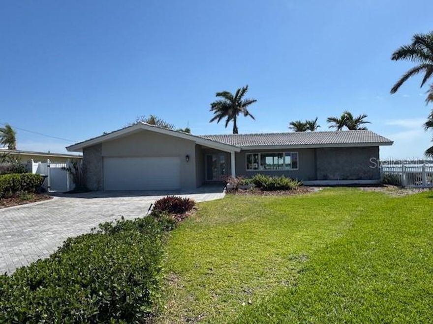 This beautiful Treasure Island home is situated on a stunning point property with 166 feet of wide open water views!  Beyond its attractive covered entry, step inside this lovely residence and feel the rich welcoming spaces of a fine split bedroom floor plan and its design emphasis on waterfront living. The elegant living area transitions to an open dining space – both with views of the waterfront. The fine, updated contemporary kitchen offers gorgeous water views, exceptional counter surfaces, shaker style cabinetry, striking tile backsplash, stainless steel appliances, unique open built in wrap-around cabinetry to the living area, and a passthrough to the waterfront lanai. The separate family room opens to the waterfront lanai and has a built-in entertainment center. The Living room/dining, family room and kitchen all have sliding doors/windows that pocket into the walls, enabling a fantastic indoor-outdoor living environment when desired. Overlooking the waterfront, the owner’s suite contains a sizable walk in closet and full private bath. The second bedroom is sizable, has private views of the waterway and a spacious walk-in closet. The third bedroom has two large walk-in closets. Step out to the 360sqft screen enclosed lanai and take in serene, unforgettable open water views that stretch for a mile across Boca Ciega Bay and the Intracoastal Waterway. Outside the lanai, you’ll discover wide, expansive and richly manicured grounds with towering Royal Palms, lush subtropical vegetation, meandering brick paver pathways and a fabulous private Zen/meditation garden overlooking the water. Updated dock has a seating bench, fish cleaning station, step down platform for kayaks/paddleboards and a 10,000 lb boat lift for fast, easy access to the Gulf of Mexico. You’ll appreciate the hurricane impact windows/sliders and the peace of mind that they provide. Located in one of Tampa Bay’s best boating communities close to shopping, dining, entertainment and the world class beaches to Treasure Island. This is a rare “point property” opportunity with huge panoramic views that only 166ft of seawall can deliver.