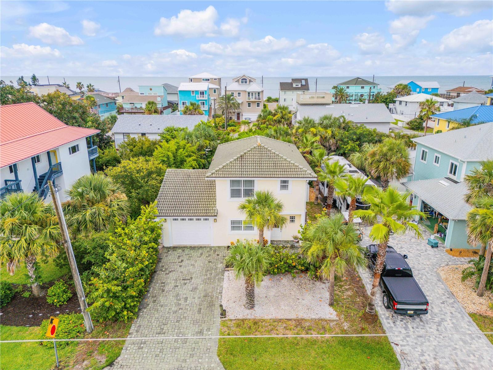 Calling all fishing, surfing, and sun-loving enthusiasts—this is your coastal dream come true. Just steps from the ocean, this solid two-story concrete block home offers the perfect blend of durability, comfort, and laid-back beach lifestyle. Whether you're heading out to catch the morning swell or spending your evenings casting a line, you'll love coming home to this thoughtfully designed retreat. The oversized 32-foot-deep garage is a rare find—perfect for storing a boat, surfboards, or all your outdoor gear. Inside, the main level features a bright and open layout with a modern kitchen, designated dining area, comfortable living space, and a convenient half bath for guests. Upstairs, you'll find two spacious ensuites with walk-in closets and a charming hallway nook ideal for a study space, reading area, or showcasing your favorite coastal decor. The primary bedroom opens to a large private balcony with ocean views—an ideal spot for morning coffee or evening breezes. Built with concrete block on both floors and topped with a classic Spanish tile roof, the home includes impact-rated windows and sliders for peace of mind. Additional features include newer stainless steel appliances, a 2013 HVAC system, central vacuum, hot and cold outdoor shower, irrigation system, and a paver driveway and back patio. The backyard is fully enclosed with a six-foot vinyl privacy fence, offering a great space for entertaining or relaxing after a beach day. Located outside of a flood zone and has never flooded, this home is move-in ready for your next adventure. Bring your boat, your board, and your beach towel—your Florida lifestyle starts here.