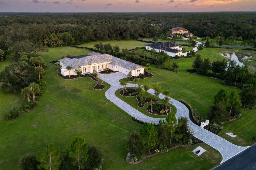 This custom-designed home, built by Anchor Homes, is a warm and inviting, Florida Coastal-style luxury home that offers a tranquil setting on a 4.38-acre lot in The Forest at Hi Hat Ranch. The Forest at Hi Hat Ranch is a gated community offering only 54 homesites with no two homes the same. Set on one of the last lots toward the rear of the community, the inspired floor plan of this home takes full advantage of the natural beauty of the land and its peaceful sceneries with all main living areas viewing the pool, lanai, and the lush surroundings this location offers. The exterior doors in the main areas of the home open to create a seamless indoor-outdoor Florida living experience. The home’s centerpiece is the spacious and inviting kitchen, great room, and dining area, featuring wood coffered ceilings in the kitchen, wood beams in the great room, custom hickory wood flooring (throughout the home) and a gas decorative fireplace. The kitchen boasts a 10-by-7-foot island with White Wave granite, a specialty refrigerator drawer, freezer/icemaker drawer, wine cooler, Bosch dishwasher, warming drawer, and microwave drawer. This showpiece area of the home is the perfect hub for daily activities and entertaining guests. The roomy owner’s suite overlooks the poolside and has a large double-entry closet with room for everything and more. The lavish master bath has a substantial walk-in shower, a separate soaking tub, dual vanities, and a private outdoor courtyard area with shower. All guest bedrooms have en-suite baths and closets already upgraded with organizers. The office has custom built-ins with a set of exterior doors, so you always have fresh sunlight and a view of the front yard. The den/TV room provides an additional space for relaxation and opens to the pool and lanai. The poolside bonus room/bedroom suite has a kitchenette and a full bath and is perfect as an in-law suite, an extended stay guestroom, or an additional office. The outdoor living area is enhanced by a fireplace, an outdoor kitchen, and multiple spaces for all types of outdoor furniture. The heated pool and spa invite you to enjoy the Florida lifestyle day and night. Imagine having a screened lanai that is approximately 1,900 square feet of outside living. This home also features a large inviting front porch, custom exterior doors, custom window coverings (including plantation shutters), wood cabinetry, 12-foot ceiling heights, Wolf appliances, luxury hickory hardwood flooring throughout, a large laundry room with sink, counterspace, and a specialty shower for pets and an extra-large three-car garage. Approximately 10 minutes to I-75 and about 25 minutes to Siesta Key; you will absolutely want to come and preview this private and tranquil lifestyle. You will immediately come to enjoy the quiet calmness of nature, birds chirping and deer who stop to watch you go by. Call for your private appointment today.