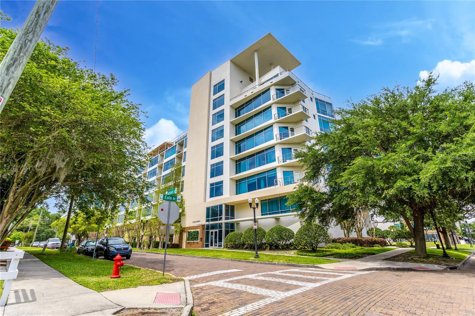 One or more photo(s) has been virtually staged. Experience elevated city living in this 2-bedroom, 2-bath condo in The Jackson, a boutique mid-rise located in the heart of Thornton Park—one of Downtown Orlando’s most desirable and walkable neighborhoods. Designed with a spacious open layout and split-bedroom floorplan, the unit features luxury vinyl flooring throughout and a sleek kitchen with granite countertops and stainless-steel appliances that seamlessly connect to the living area, ideal for entertaining. Adjacent to the kitchen is a bonus prep area with matching granite countertops and similar cabinetry, along with in-unit washer and dryer. Expansive windows fill the space with natural light and open to a private patio, creating a tranquil urban retreat. The primary suite offers an oversized window overlooking the balcony, along with an en-suite bath featuring dual sinks and a newly renovated walk-in glass shower. The guest bedroom is positioned on the opposite side of the unit for added privacy, and the laundry area includes built-in cabinetry for extra storage. Residents enjoy two secured garage parking spaces, 24/7 building security, an onsite fitness center, and unbeatable proximity to Lake Eola, the Dr. Phillips Performing Arts Center, and downtown’s best dining, shopping, and nightlife. Just 23 minutes to Orlando International Airport and 25 minutes to Disney, this condo blends luxury, convenience, and the vibrant energy of city living.