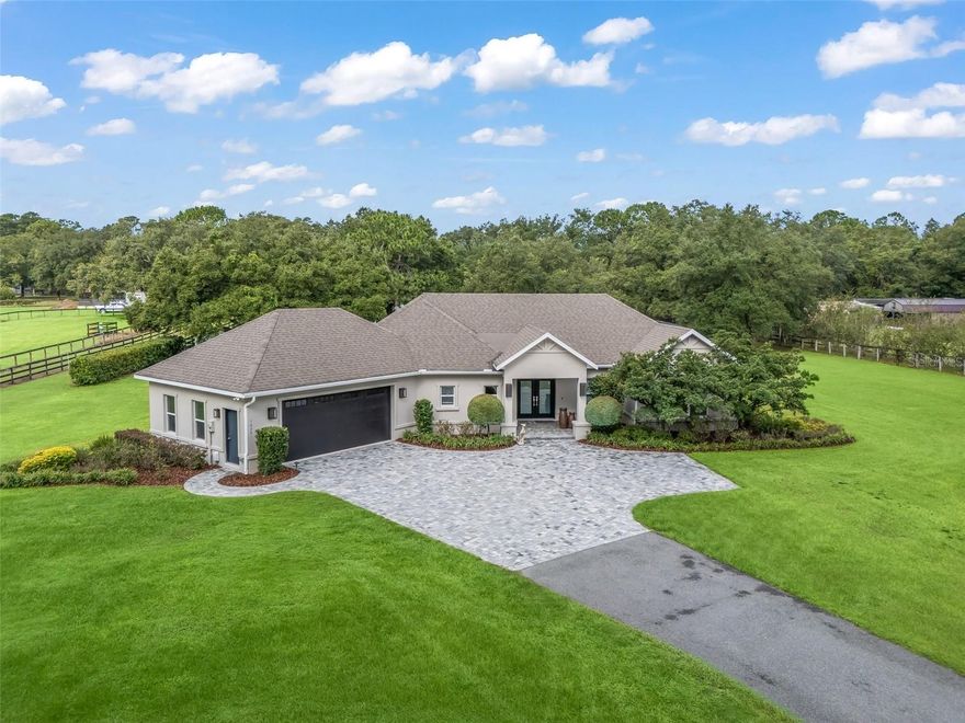 Beautiful mini farm on 3 acres just one block from WEC! Fall in love with the lush landscape and ample acreage surrounding this lovely residence. The recently constructed custom home boasts an open floor-plan, beautifully appointed kitchen with vast island and huge hidden pantry, living area with stately stone fireplace, separate office, large master and en-suite with spa like finishes, spacious guest rooms and a gorgeous, screened patio area overlooking 2 large green paddocks with run-in stalls, and shady live oaks in the back yard. Don't miss this opportunity to own a private paradise within steps of the World Equestrian Center!