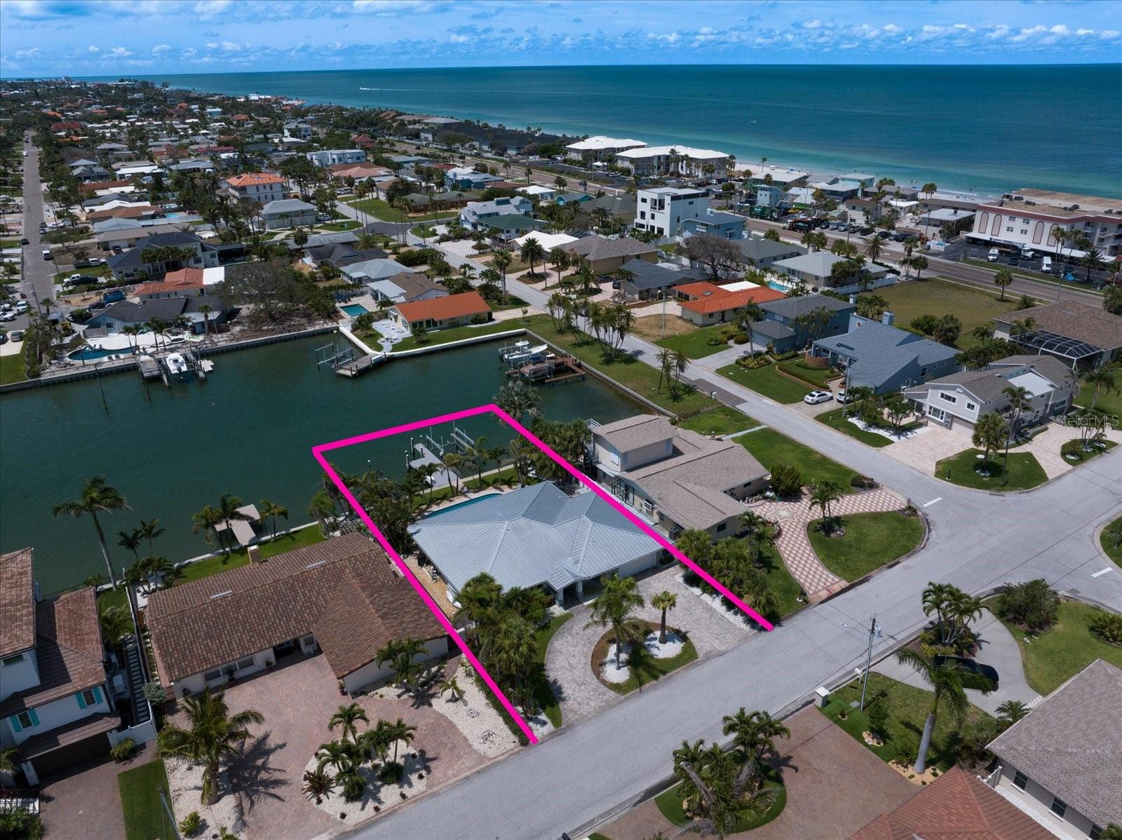Located in the prestigious enclave of Belleair Beach, this impeccably maintained waterfront residence is a true coastal dream home offering luxury, functionality, and the ultimate Florida lifestyle. With direct access to the Intracoastal Waterway, a composite 2023 dock, boat slip, and 13,000lb lift, this home is a boater’s paradise in one of the Gulf Coast’s most desirable communities. From the moment you arrive, the home impresses with striking curb appeal, a pavered circular driveway, lush tropical landscaping, and a durable 2019 metal roof. Impact-rated windows and doors provide added peace of mind, while the beautifully updated interior offers timeless coastal elegance throughout. Step inside to a bright, open-concept floor plan enhanced by wood-look tile flooring, plantation shutters, crown molding, and designer lighting. The spacious living and dining areas are perfect for relaxing or entertaining, and the adjacent gourmet kitchen is a showstopper—featuring quartz countertops, stainless steel appliances, a breakfast bar, and breathtaking pool and water views from the kitchen window. Glass sliders open to a resort-style backyard complete with a heated and chilled pool, expansive paver patio, and a fully equipped outdoor kitchen with gas cooktop and side burner—ideal for grilling the catch of the day. A convenient pool bath with walk-in shower adds to the home’s thoughtful design, allowing you and your guests to fully enjoy the outdoor living experience. Wake up to water views from the sunlit primary suite, which features private access to the pool and patio. The spa-inspired ensuite bath includes double vanities, a garden tub, a walk-in shower, and a custom walk-in closet. Three additional bedrooms feature generous closet space with custom shelving and share a well-appointed full bath. The oversized garage includes abundant storage and a fourth full bathroom for added convenience. Outdoors, enjoy watching dolphins, manatees, and seabirds, or unwind beneath the stars with built-in landscape lighting, surround sound speakers, and unforgettable sunset views. Whether you're seeking a full-time waterfront residence or the ultimate vacation retreat, this move- in ready home delivers on every level. Located just minutes from the Belleair Causeway, world-famous Clearwater Beach, boutique shopping, and fine dining, this exceptional property captures the very best of coastal living.