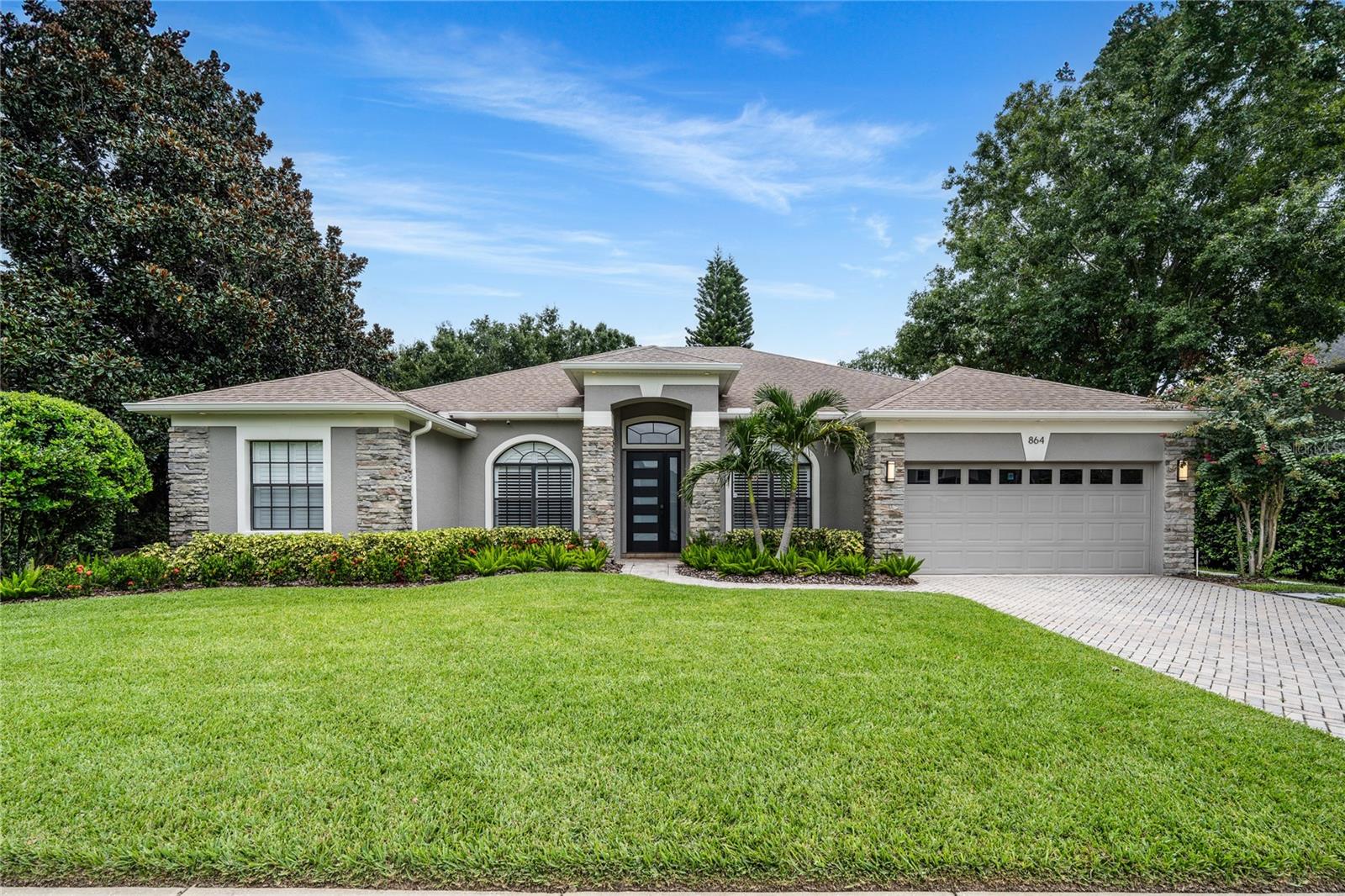 Welcome to your private oasis in the highly sought-after Reserve at Lake Mary! This stunning 4-bedroom, 3-bathroom single-family POOL home is nestled in a tranquil neighborhood, offering both comfort and convenience. This home boasts an array of custom features designed to enhance your lifestyle. From the moment you arrive, the curb appeal draws you in with tropical greenery, stack stone, paver driveway and contemporary accents. Once inside you will be wowed by the upgrades and designer features that repeat throughout the house. This includes plantation shutters, archways and gorgeous wood-look tile plank flooring that flow from room to room. Off the foyer is a cozy living room/office and dining room both with custom wainscoting, paint and artisanal lighting. Through the built-in butlers pantry you enter the sleek kitchen with quartz countertops, stainless appliances, modern hardware/lighting and crisp light cabinetry. The oversized island opens the main living area and breakfast nook offering the perfect blend of contemporary style and classic comfort. This 3 way split plan has 2 bedrooms off one hall that share full bath with, spa tub, stand up tiled shower, vanity and ambient lighting. Bedroom 3 is tucked away behind stunning, custom made reeded glass doors and has its own full bath with modern glass shower. The oversized primary suite features plantation shutters, pendant lighting and designer thatched wallpaper and overlooks the backyard. The ensuite bathroom offers dual vanities, quartz countertops, custom lighting/tile shower and walk-in closets with built-ins. Large sliders off the family room draw you outside to your covered patio with wood ceiling and unobstructed landscape views through upgraded seamless screen enclosure. Salt water pool features clean lines, tiled deck and artisan fountain offering a serene, luxury feel to this private oasis. Located in an established neighborhood known for its charm and convenience, this home is close to top-rated Seminole Co schools, shopping, dining, parks, and major highways I4/417 and 429. Roof 2020, HVAC 2023. HOT water Heater 2024. Don't miss the 2 car garage with epoxy floors and metal celling racks for additional storage. This custom HOME is the perfect blend of LUXURY, location, and lifestyle and will not last long!