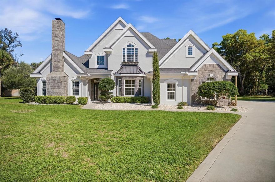 A storybook home tucked behind private gates on a coveted cul-de-sac, offering a rare sense of elegance and timeless charm. Better than new, this beautifully appointed 4-bedroom, 3.5-bath residence offers 3,324 square feet of refined living space, thoughtfully designed to blend timeless elegance with elevated Florida living. Set on an expansive and private homesite in Ormond Beach, the home showcases sophisticated interiors with soaring ceilings, rich wood flooring, custom millwork, and a seamless, open-concept layout ideal for both everyday living and upscale entertaining. The main living areas are enhanced by architectural detailing and flow effortlessly to the outdoor living space, while the chef’s kitchen features granite countertops, custom cabinetry, stainless steel appliances, and a sunlit breakfast area overlooking the grounds. The primary suite serves as a serene retreat with direct access to the lanai and a spa-inspired bath complete with dual vanities, a walk-in shower, and a generously sized custom closet. Additional bedrooms and versatile living spaces offer comfort and flexibility for guests, a private office, or secondary lounge areas. Outdoors, a resort-style setting awaits with a sparkling pool and sun shelf, expansive patio space, a covered lanai, and a fully equipped outdoor kitchen designed for effortless entertaining, all framed by lush, mature landscaping and a large fenced lawn. A stately exterior with stone accents, manicured grounds, and an expansive driveway further enhances the home’s presence, creating a polished and private estate feel. This exceptional property delivers a sophisticated yet relaxed lifestyle in one of Ormond Beach’s most desirable settings.
