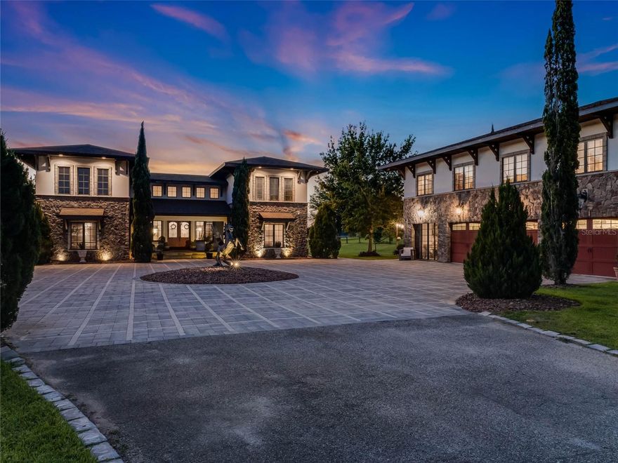 Welcome to this exquisite estate, where luxurious living and grand-scale entertaining come together in perfect harmony. Inspired by the breathtaking beauty of the Amalfi Coast, this Tuscan-style custom-built equestrian home is a true testament to unparalleled luxury. As you pass through the large iron gates, you'll be captivated by the sheer elegance and sophistication that awaits. Nestled on over 7 acres of meticulously manicured grounds, this private gated estate showcases flowing fields and equestrian stables, accompanied by a remarkable 6-vehicle showroom with a guest suite above. The main house spans an impressive 5,000 square feet under air and is gracefully positioned on a pristine lakefront lot, offering captivating views at every turn. Upon entering the double front doors, you'll be greeted by warm earth-colored stone and cedar soffits, seamlessly blending contemporary elements with old-world charm. The exquisite bird's nest staircase beckons you to explore the entertainment possibilities found in multiple courtyards throughout the property. The interior boasts Chicago brick accents, custom stone work, and high coffered tray ceilings adorned with tongue and grove inlays. This home effortlessly balances designer elegance with comfortable living spaces, featuring 3 bedrooms, 4 bathrooms, 2 office spaces, a media/theatre room, and multiple living areas that gracefully flow around the courtyard, pool, and entertainment spaces. The gourmet chef's kitchen is a masterpiece, seamlessly blending charming European influence with modern convenience. A 12-foot Italian marble center island takes center stage, surrounded by custom high-end cabinetry and top-of-the-line Jenn-Air appliances. The ample natural light cascades through floor-to-ceiling windows, emphasizing the indoor/outdoor flow and highlighting the beauty of the home. White custom cabinets and dark wood beam ceilings add depth and character to this culinary haven, while the island seating for 6 invites guests to gather and indulge. Adjacent to the kitchen, a courtyard-style pool awaits, enveloped by vibrant bougainvillea trellises, creating a serene oasis for relaxation and entertainment. The primary retreat offers a private entrance, panoramic views of the lake, pool, and courtyard, and custom Chicago brick accents. Inside, you'll discover recessed curtains, a fully walk-in closet/bathroom, and custom Italian countertops for the dual vanities. Beyond the main residence, the property offers an array of exceptional features. A fully functioning Airbnb above the garage boasts 4 bedrooms, 2.5 baths, and 1,900 square feet, providing additional space for guests or potential income. A beautiful 2-stall barn with a tack room, along with the option for 2 additional stalls, perfectly complements the design elements of the home. Discover a private courtyard here, where you can unwind and immerse yourself in the serene beauty of nature. The garage is a car enthusiast's dream, featuring 4 spaces with a 4-post lift , a third office space, and a dedicated gym room, all comfortably climate-controlled. This extraordinary property offers the rare combination of land, lakefront access, and unparalleled luxury in the rolling hills of Clermont, Florida. It effortlessly recreates the ambiance of a family member's olive farm off the Amalfi Coast, bringing the essence of European splendor to the Sunshine State.