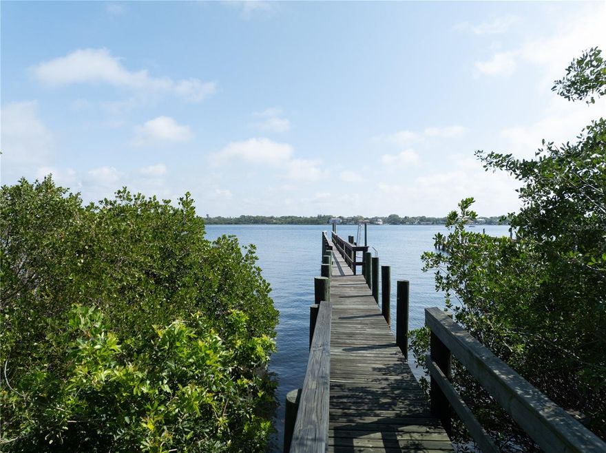 This rare and coveted 1-acre flag lot extends down to the Little Sarasota Bay waterfront in one of the most desirable locales on the sandy barrier island of Siesta Key, across the street from the prestigious Sanderling Club. Imagine a canopied driveway leading to your secluded dream home, with immediate access to all that Siesta Key and the emerald green waters of the Gulf of Mexico and the Intercoastal Waterway have to offer. You will enjoy your personal gateway to endless aquatic adventures, including boating, fishing, kayaking, paddleboarding, and shelling, or just relaxing on the beach. Stroll to your private dock extending approximately 235 feet into the bay waters, capable of docking a boat, jet skis, and kayaks. Walk or cycle 0.3 miles to the limited access Point of Rocks beach, a unique snorkeling and scuba diving spot, at the southern end of the world-renowned Siesta Key Beach, famous for its powdery white sands and calm, crystal clear waters. The Key’s South Village, adjacent to the island’s south bridge to the mainland, is a mere 0.7 miles from your front door. In addition to Siesta Key’s best beach bars, South Village has a shopping area, grocery store, restaurants, fish market, and beach rentals, as well as a Marina, where your recreational boating needs abound. You won’t want to leave your new digs, but there is a lot more to this area. A tropical paradise married to a clean, vibrant city with a historic downtown is a rare combination, but it’s yours, only 7 miles up the coast in Sarasota, making it the epitome of Florida’s Sun Coast living! In addition to its charming feel, Sarasota boasts a world-class Arts and Entertainment scene, with an array of upscale shops, gourmet restaurants, and vibrant nightlife venues to lure you out of your beach home for a “night on the town.” Indulge in a performance of a classic opera at the internationally acclaimed Sarasota Opera House, or catch a live blues show in a waterfront bar. Come claim your piece of Paradise!  DRONE VIDEO ATTACHED TO THE LISTING!  ***Also being offered as a land home package at MLS# A4622370***