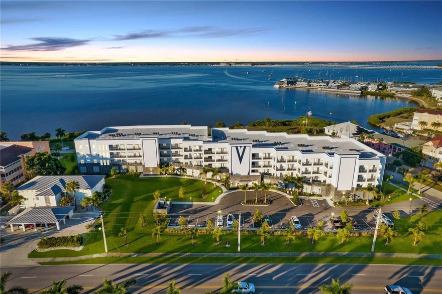 UPGRADES ABOUND IN THIS 3rd FLOOR HARBORFONT CONDO with 2 PARKING SPACES at Paradise POINTE! Incredible UNOBSTRUCTED HARBOR VIEWS draw you into this FABULOUS LUXURY CONDO at the NEWEST HARBORFRONT Condo Complex- PARADISE POINTE- in Punta Gorda Isles. This property has A 174 square foot covered & tiled balcony overlooking the harbor with direct views of Fishermen's Village and the new Sunseeker Resort, along with amazing sunsets & sunrises, with a wall of impact rated pocket sliders that open up the interior of the unit to the outdoors. Inside, find 24"x"48" porcelain tile throughout with solid wood doors, quartz counters, soft close cabinetry, custom trim work and ceiling details, fans both inside and outside, custom glass light fixtures, & a great layout where every square inch of space is utilized perfectly. The guest bedroom has an en-suite bathroom and walk-in closet, as does the master suite, with 2 closets, a separate soaking tub and glass/tile shower with dual vanities. An inside utility room with extra cabinetry and a storage closet are just down the hall along with a 1/2 bathroom located just off the main living areas for guests. The kitchen, dining, and living areas are all open and perfect for entertaining, with beautiful finishes from top to bottom, including new stainless-steel appliances, light fixtures, tile backsplash, new paint throughout, and custom Plantation Shutters. The property was built with concrete pilings, walls, and floors, and impact rated windows and doors, and has upgraded high-speed internet access/security in every unit. Paradise Point has a massive swimming pool and spa, keycard access to the secure lobby and elevator, 24 camera security, 2 under building parking spot-SPACES 33 & 34, luxurious landscaping, & a covered fire pit/recreation area with grills. Nearby to Fishermen's Village, Downtown Punta Gorda, Ponce Park & boat ramp, St. Andrews South Golf Course, and other great local waterfront amenities, along with access to several airports for easy travel, come see why Paradise Point should be your new home for the Southwest Florida lifestyle of your dreams!