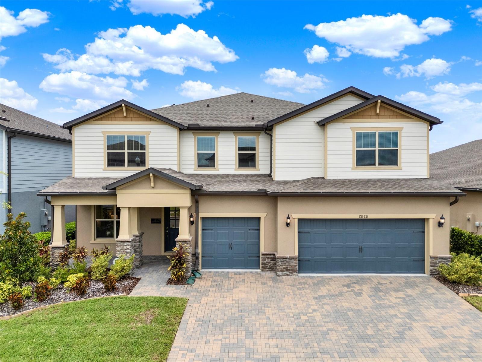 Prepare to be amazed by this expansive, luxurious, Craftsman-style pool home, ideally positioned between the rapidly growing communities of Lake Nona and Sunbridge. With 5,246 square feet of thoughtfully designed living space, this home offers exceptional versatility, ideal for large families, multi-generational households, or those seeking room to grow, entertain, and live in comfort and style. As you enter through the welcoming front porch, you’re greeted by an entry hall leading to a bright, open living space connecting the kitchen, dinette, and great room in the heart of the home. The gourmet kitchen is truly the centerpiece, featuring crisp white cabinetry, quartz countertops, stainless steel appliances including built-in oven and microwave, a dramatic tile backsplash, and a massive center island with seating. Entertain with ease thanks to a custom walk-in pantry with extensive shelving and a second full-sized refrigerator—perfect for families who love to cook, host, and stay organized. Downstairs, the layout is ideal for multi-generational living, with two bedroom suites on the first floor including the luxurious owner’s retreat. This primary bedroom features a spa-inspired bathroom with dual sinks, a glass-enclosed walk-in shower, and a beautifully appointed custom walk-in closet with center island. The first floor is rounded out by an intimate bar area with a dual-zoned wine cooler, pendant lighting, and custom barn doors hiding a convenient storage space. Upstairs, you'll find five additional bedrooms, three full bathrooms, and a sprawling loft area that provides abundant room for play, work, or relaxation. Tucked behind double doors, a fully equipped home theater with tiered flooring, electric blackout shade, and pre-wired surround sound transforms movie nights into a true cinematic experience. This home has been enhanced with numerous elevated features, including wood-look tile flooring, upgraded lighting fixtures, custom closet systems, and tremendous amounts of built-in storage. The entry from the three-car garage includes a custom drop zone, ideal for backpacks, shoes, and everyday essentials. Step outside and discover a true oasis for your Florida lifestyle. The backyard has been transformed into a private retreat with a solar-heated pool as its centerpiece, featuring tranquil waterfall features, a sun shelf with fountain and umbrella anchor, and lush tropical landscaping. The covered, brick paver lanai provides all-weather comfort with electric retractable sun shades, while the outdoor summer kitchen with built-in grill and bar seating is ready for weekend gatherings. The fully fenced yard is both pet- and kid-friendly, offering peace of mind and privacy. Located just 5 minutes from Publix and within close reach of Lake Nona's Medical City, Sunbridge, Orlando International Airport, and top-rated schools including Narcoossee Elementary and Middle, and Tohopekaliga High School, this home provides the perfect blend of lifestyle, location, and value. Community amenities include a resort-style pool and playground, with beautifully maintained green spaces and sidewalks ideal for evening strolls. This is a rare opportunity to own a move-in ready estate with unparalleled square footage, elegant upgrades, and unbeatable proximity to some of Central Florida’s most exciting growth corridors—all without the Lake Nona price tag. Schedule your private showing today and come experience the lifestyle this exceptional home has to offer.