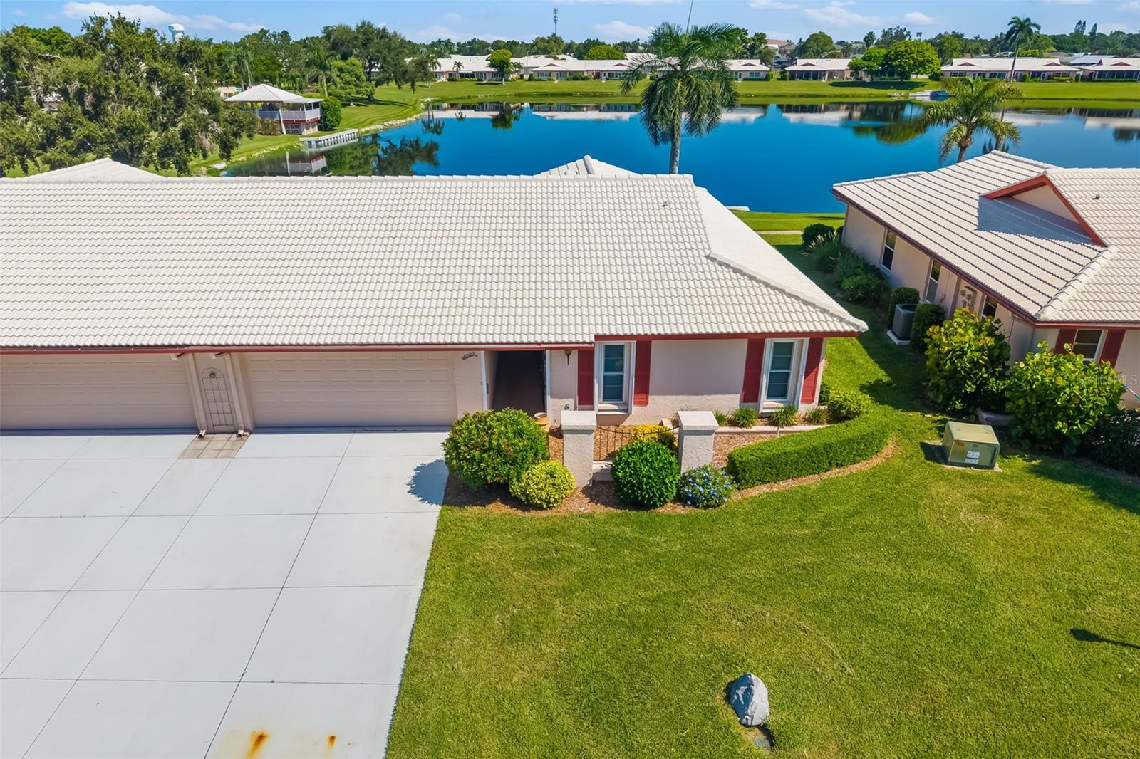 LAKEFRONT paired villa condo in Section 12 of West Bradenton's 55+ Village Green maintenance-free community! Coastal vibes inside and out this beauty. 2bd 2fb 2c attached garage 1913 square feet. Level floors and natural light. Both bedrooms have full wall-length closets. Both baths have been updated. Additional updates include modern look wood tile flooring throughout, kitchen appliances 2025, AC 2024, replacement windows (except garage), barrel tile roof 2006. Laundry is inside thee home. Garage has storage cabinets. The front of the home faces south while the back faces north. Section 12 offers a community pool, pavilion, and sidewalks from each home that loop around picturesque Mirror Lake with benches for relaxing and sightseeing. The community pool and lake are steps away outside the back door and patio. Village Green is an active and friendly community with 426 villa style condo units. It has 12 sections, each with independent associations. Anna Maria Island beaches are 5.5 miles away. Palma Sola Causeway is 1.5 miles away and is pet friendly! Cortez Fishing Village with locally owned restaurants and novelty stores and entertainment venues is also about 5.5 miles. Enjoy fine and casual dining, world renowned beaches with sugar soft sand made of 99% quartz, live theater, art galleries, farmers markets, shopping malls and boutiques. This home offers the ideal Florida lifestyle! Nearest airports are SRQ, TPA, PIE.