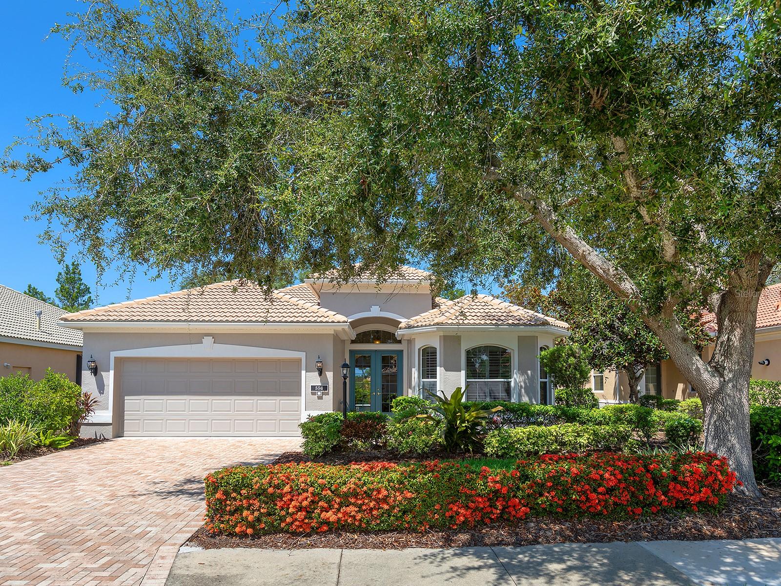Welcome to a beautiful residence where comfort, privacy, and functionality come together seamlessly. A paver driveway, tile roof, mature landscaping, and a charming paver walkway set the tone as you arrive, leading to an inviting French door entry framed by a transom window. Inside, tile floors stretch through the main living areas, beginning with a light-filled foyer adorned with a chandelier. Flowing effortlessly into the heart of the home, the dining area offers an elegant setting for entertaining, complete with a chandelier and a niche perfectly sized for a buffet or credenza. The adjacent great room impresses with a wall of sliding glass doors, double tray ceilings, recessed lighting, a ceiling fan, and a built-in media niche, creating a bright and open space ideal for everyday living. The kitchen is both stylish and practical, featuring warm wood cabinetry, solid surface countertops, a glass block window in the backsplash for additional natural light, and an eat-in area with a picturesque aquarium window. A breakfast bar provides casual seating, and two closet pantries offer ample storage. The kitchen is outfitted with LG stainless steel appliances, including a range, microwave, dishwasher, and refrigerator. Tucked privately at the back of the home, the spacious primary suite offers a serene retreat with a tray ceiling, multiple windows, and a cozy sitting area with sliders opening to the lanai. Two walk-in closets provide generous storage, while the en-suite bathroom includes a large vanity with two sinks and a makeup area, a soaking tub, walk-in shower with bench seating, a framed mirror, water closet, and a glass block transom window that brightens the space. Just off the foyer, a pocket door leads to a private guest wing that includes a full bathroom with a tub/shower combo, vanity, and tile flooring, as well as a spacious guest bedroom featuring plush carpet, plantation shutters, and a generous closet. The second guest bedroom, located just across the foyer with double doors, is currently set up as a home office but offers flexibility as a guest room, complete with its own closet and a large window. Additional highlights include a well-appointed laundry room with a sink, cabinet workspace, shelving, storage closet, and central vacuum system, plus a tile floor and pocket door for added convenience. Step outside to a covered lanai with sitting and dining areas, ceiling fan, and plenty of room to relax or entertain, all surrounded by lush, mature landscaping for enhanced privacy and tranquility. Willowbend is a maintenance-free neighborhood rich in amenities, including a clubhouse with fitness center, playground, pickleball courts, and a large, heated pool available to all homeowners. All this plus lawn maintenance (including weeding, trimming, sprinklers and irrigation), cable TV, and internet. This fantastic location is ideally near downtown Venice, Sarasota, Siesta Key, Casey Key and Nokomis Beach—offering easy access to beaches, cultural attractions, shopping, and dining. Also nearby is the Legacy Trail, Oscar Scherer State Park, Pine View School, and award-winning Gulf beaches.