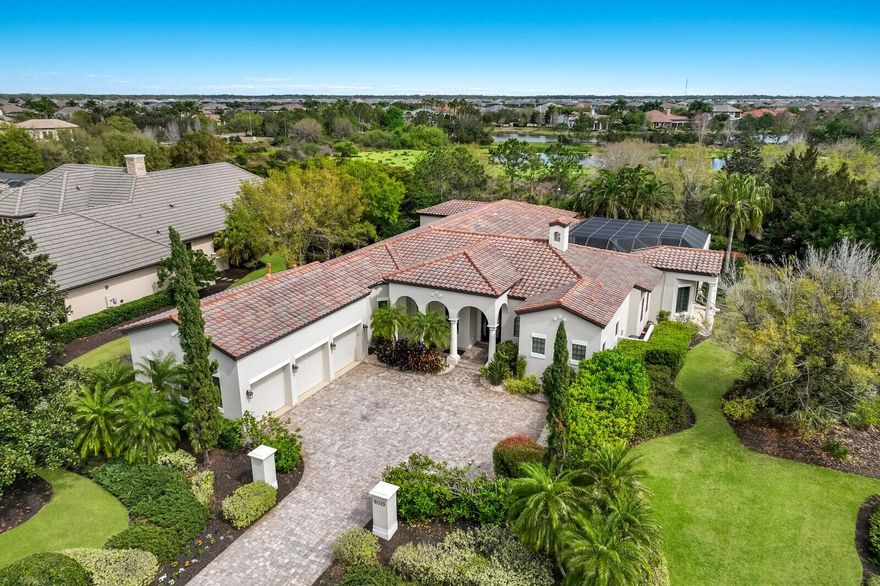 This stunning retreat nestled in the exclusive enclave of the desired Lake Club is a true masterpiece of luxury living. With its impeccable design and exquisite features, this custom-built home by Anchor Builders offers a tranquil and private escape.  The estate sits on a spacious .80-acre lot, providing complete privacy and breathtaking views of serene waters and lush landscaping. Crown molding, stone fireplace and custom designed and crafted shelving are a few of the classic designs this home boasts.  The luxurious master suite includes a retreat space and a beautifully appointed ensuite bathroom and 2 built-in custom closets. Culinary delights are created in the heart of the home with state of the art appliances, wood cabinetry and walk-in pantry.  Entertaining is a breeze with the resort-inspired pool and spa, accompanied by a gourmet outdoor kitchen that rivals the finest culinary establishments. Additionally, there's a dedicated pool entertaining room with an attached bathroom for added convenience. This home offers versatility with three flex spaces allowing for endless possibilities such as a home gym, office, or creative studio. The Lake Club,  provides a picturesque lakeside setting with world-class amenities including a luxurious clubhouse, swimming pools, fitness centers, tennis and pickle ball courts, and scenic walking trails. Situated in the heart of Lakewood Ranch, this property offers easy access to upscale shopping, dining, and entertainment options. Don't miss out on the opportunity to experience luxury living at its finest. Schedule your private tour today!