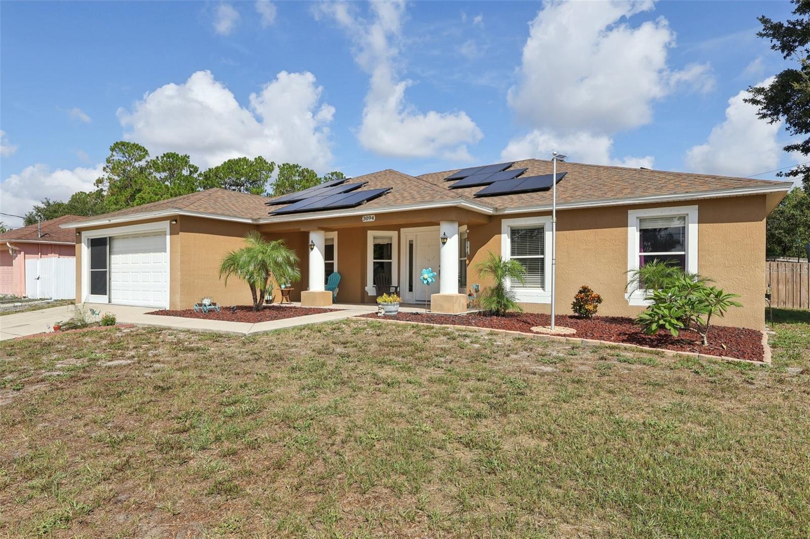 Check out this gorgeous, spacious, contemporary-style 4 bedroom, 2 bath home built in 2008 offering 2,489 sq ft of thoughtful living space on a high-and-dry ¼-acre lot. The tri-split, open floor plan features a family room, 22x23 formal living and formal dining room with volume ceilings, plus a bright 22x13 Florida room under heat and air with access to the 14x16 primary suite and pool ready guest bath. Beautiful laminate flooring and ceramic tile flow throughout, complemented by a beautiful shiplap accent walls in the living room. Enjoy a large kitchen with breakfast nook, breakfast bar, ample cabinets, walk-in pantry, stainless-steel appliances and inside utility. large 13x10 primary bathroom features a garden tub and walk in closet. Outside, a fully fenced backyard with open patio overlooks a pool-ready site; hurricane shutters, newer lighting, large front porch, and garage screen door add convenience and value. Recent updates include a 2021 roof, septic pumped four years ago, and assumable solar panels or seller to pay off with a acceptable terms. VA loan assumable with a low rate. Minutes to I-4, 20 min to beaches, 30 min to Orlando, with Deltona’s world-famous golf course, Amazon fulfillment center, shopping and medical facilities close by. Owner took pride in this move in ready home. Call today before this Home says "SOLD"