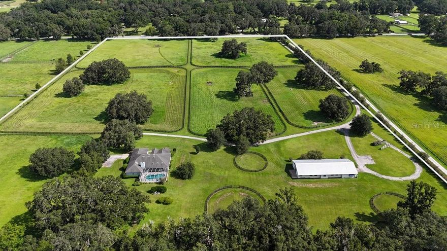 Equestrian Retreat in Prime NW Location
24.17+/- acre location, perfectly perched on a scenic knoll. This exceptional residence boasts 4 spacious bedrooms and 3 well-appointed bathrooms, offering ample space for comfort and relaxation. The chef's kitchen is open to the family room, creating a seamless flow for entertaining and family gatherings. This open layout enhances the overall livability of the home, making it a perfect space for both everyday activities and special occasions.  Step outside to enjoy the expansive covered lanai and the inviting screen-enclosed pool—ideal for entertaining or unwinding in your private oasis.
Equestrian enthusiasts will appreciate the 10-stall center-aisle concrete block barn, complete with an efficiency apartment, office, and a tack/feed room, providing convenience for all your riding needs. The property is surrounded by 6 lush paddocks and 4 round pens, ensuring your horses have the best environment to thrive.
Additionally, a detached garage offers the perfect space for tools and storage of farm equipment, making maintenance effortless.
Situated among premier destinations, including the Adena Golf and Country Club, Golden Ocala Golf & Equestrian Club, and the renowned World Equestrian Center, this property is a haven for an active lifestyle. Residents can relish world-class equestrian events, top-notch golf, delightful dining options, and vibrant shopping, all while enjoying year-round festivities.
Don’t miss the chance to own this magnificent property that combines luxury living with equestrian excellence. Schedule your showing today!