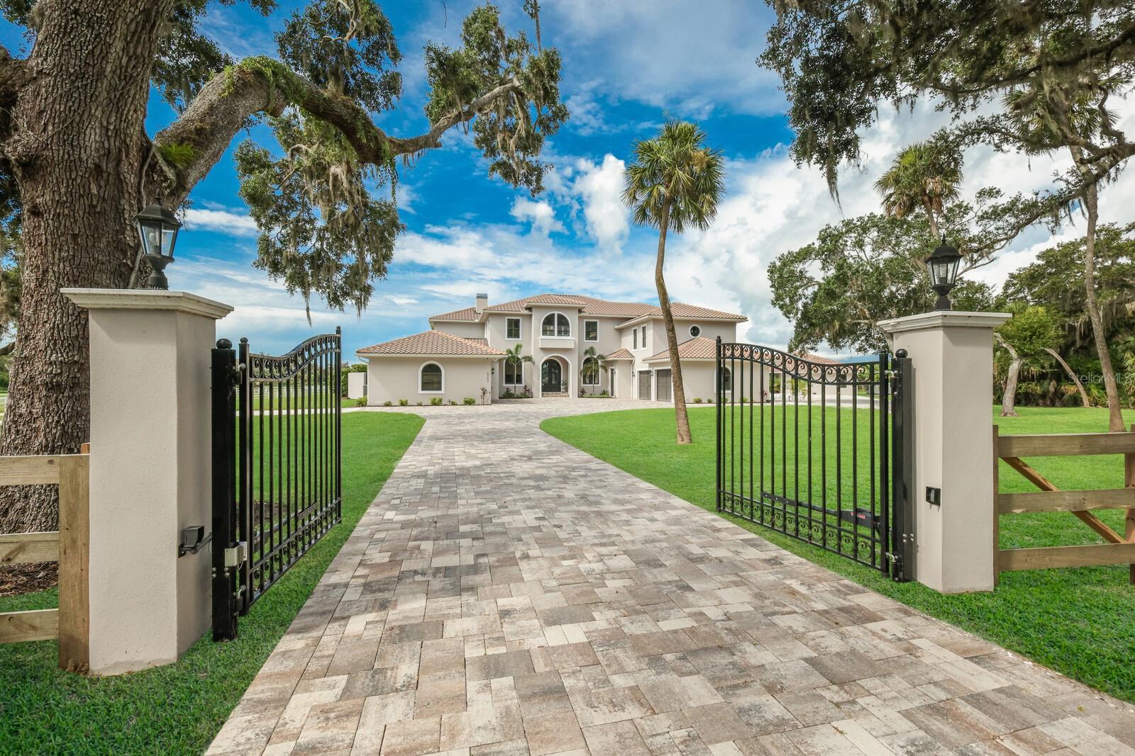 This warm and inviting custom designed home is luxury country living at its finest and is nestled on a tranquil equestrian estate in Myakka Valley Ranches. The expansive estate boasts a generous land area with two separate lots totaling 12.36 acres, of which 5.23 acres remains undeveloped providing ample space to bring your ideas to life. Whether you envision constructing a second home, creating a private family retreat, or establishing a lucrative business venture, the additional parcel offers the canvas for your dreams to flourish. Construction of this home was fully finalized in 2021, with several additional upgrades made by the current owner through 2023, making it like NEW. With 8,140 square feet of living space, this home provides plenty of breathing room. Luxury features include an elevator, 12ft ceilings on main floor, 8-foot solid-core doors, plantation shutters throughout, whole house generator system, whole house RO system, power gated entry, spray foam insulation, nix mosquito system around residence and barn, solid-wood soft close cabinetry throughout, impact-resistant tinted glass windows/sliders and LED Lutron lighting. The lower level consists of your private office, an oversized primary suite with a step-up sunroom seating area, walk in closets as well as a spa-like oasis in your primary bath featuring a large seamless glass walk-in shower and a separate soaking tub that overlooks the private enclosed garden. On the opposite side of the home, is a second en-suite, and a spacious laundry room complete with a folding counter, sink and additional storage cabinets. The expansive living area includes a great room with a gas fireplace, creating a cozy and inviting atmosphere. The grand kitchen is a chef's dream, boasting beautiful white quartz countertops, high-end appliances, wine fridge, ice maker, and two large islands making this kitchen the perfect hub for entertaining. The kitchen overlooks the great room, breakfast nook and family room, all featuring high ceilings, recessed lighting, and tall impact glass sliding doors that offer serene views of the pool and property. The upper level offers three additional bedrooms, theater/game room, bonus room w/ kitchenette, flex room, gym, and a covered balcony. In your backyard, you'll find a large saltwater pool/spa, two screened-in outdoor living spaces perfect for relaxation, an outdoor fireplace and kitchen making outdoor entertaining a breeze. A covered breezeway from the main house guides you to the detached guesthouse that offers an additional 2 bedrooms, 1 bath and 825 square feet of living space. The captivating property includes two ponds, a creek, grazing paddocks, dressage arena, training ring with a viewing platform, an 8,000sqft foot 18-stall barn that includes a staff kitchen, office, and tack rooms. Myakka Valley Ranches is an established premier equestrian community of five-plus-acre properties with no two homes the same and offers saddle trails, nature preserves and two private waterfront parks. You can launch a kayak into Howard Creek which leads to the Upper Lake in Myakka River State Park. So, if country living is calling you, come breathe the fresh country air and relax in the splendor of this natural Florida setting. You may discover a location that will be the backdrop for a lifetime of extraordinary memories. Most furniture available for sale with separate bill of sale. Detailed feature sheet, survey and video available.