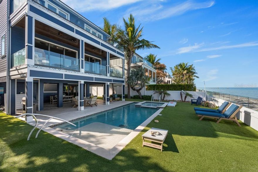 Direct Beachfront Luxury with Exceptional Rental Income on  Anna Maria Island. Discover the ultimate in coastal elegance with this direct beachfront home on the shores of Anna Maria Island. A rare beachfront home sold turnkey furnished that seamlessly blends refined luxury with a proven record of outstanding short-term rental performance. Recently enhanced with numerous upgrades including new sliding doors on the upper level—this home showcases high end finishes and expansive walls of glass that capture sweeping views of Tampa Bay and the iconic Sunshine Skyway Bridge. The spacious living and dining areas open through floor-to-ceiling sliders to a generous bayfront balcony, creating an effortless indoor–outdoor flow for entertaining or peaceful relaxation. The gourmet kitchen is a chef’s delight, featuring shaker cabinetry, a large island with seating, quartz countertops, and new premium stainless-steel appliances including a gas range. Each of the four bedrooms is a private retreat, complete with an en-suite bath and its own balcony framed by tropical scenery.  Additional recent upgrades include new ground-level outdoor furnishings, refreshed tropical landscaping with exterior lighting, and newly painted interior and exterior spaces. The covered poolside lounge and dining area on the ground level are the perfect setting for waterfront living—just steps from the sand. As evening falls, enjoy the mesmerizing glow of the Skyway Bridge from your own serene getaway.  Set on the pristine beachfront of Anna Maria Island, this home features timeless architecture, a spectacular coastal setting, and an unparalleled opportunity for both personal enjoyment and exceptional rental revenue.  This 4-bedroom, 4-bath residence produced nearly $500,000 for 2025,  $456,000 booked for 2024, and $464,000 in 2023. Future 2026 reservations in place Comprehensive rental history and future booking details for 2025 and 2026 are available upon request. A rare chance to own a true beachfront sanctuary.