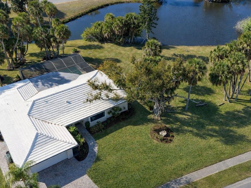 This exceptional lakefront gem is a nearly 2,000-square-foot home ready to move in, perfect for anyone seeking a beautiful, inviting space to call their own. Surrounded by the serene embrace of nature, it offers stunning sunset views that paint the sky with vibrant colors as the day winds down. Imagine relaxing by the pool while the gentle sounds of nature create a peaceful backdrop, making it the perfect retreat. Enjoy coveted privacy, with a tranquil park next door that enhances the atmosphere. Having only one neighbor on one side, you can fully appreciate the quiet surroundings. This property has 3 bedrooms, 2.5 baths, and a home office, boasting gorgeous lake views from almost every room. It includes several thoughtful upgrades, such as diagonal tile floors, plantation shutters, quality cabinetry, built-ins, recessed lighting, and pocket doors. The architectural details are highlighted by a beamed, warm-wood board-and-batten ceiling in the eat-in kitchen. You'll love this modern space, with attractive white cabinetry, bright task lighting, a complementary tiled backsplash, and premium stainless-steel appliances. Granite countertops extend into a peninsula bar for seating and match the surface of the built-in buffet in the dining area, which seamlessly connects to the living room for an ideal great room layout. A sleek glass wall partition separates the home office, providing sound insulation while allowing natural light and views throughout the main living space. Experience harmonious indoor and outdoor living with triple sliding glass doors that pocket to create an incredible flow for entertaining. Another set of sliding glass doors adds scenic charm in the primary bedroom, which has an en suite bath updated with wood cabinetry, double sinks, built-ins, and a designer-inspired shower with a glass-and-tile surround. Don’t overlook the remarkable Ove toilet, equipped with cutting-edge smart features. A convenient half bath shows stylish details, while a renovated secondary bath has dual sinks. Two additional bedrooms have walk-in closets, and a fully functional laundry room completes the freshly painted interior.  On the expansive screened lanai, a refreshing pool and a covered entertainment area await, surrounded by a custom, artistic faux flagstone cement deck that leads to a brick-paver sun patio. This thoughtful design element continues to enhance the home’s curb appeal, with the paver bricks forming pathways and a driveway that leads to the two-car garage, which has a built-in workbench with storage. Hurricane-impact-rated windows provide safety and peace of mind. Explore the perfect location with this home situated in the Gulf Gate Woods community, recognized for its deed restrictions and optional association. Just under a mile from Sarasota Bay, this residence offers a fantastic central Sarasota address, only a few minutes from the celebrated Siesta Key beach. The neighborhood is part of a highly sought-after school district, with Gulf Gate Elementary School less than 2 miles away, Riverview High School zoned, and a quick drive to Pine View School. You'll find a wide array of shopping options nearby, and it is conveniently close to the Gulf Gate Public Library. Enjoy easy access to local attractions, including remarkable white-sand beaches, premier golf courses, Potter Park, and the Selby Aquatic Center, as well as numerous recreational facilities such as the YMCA and Legacy Trails.