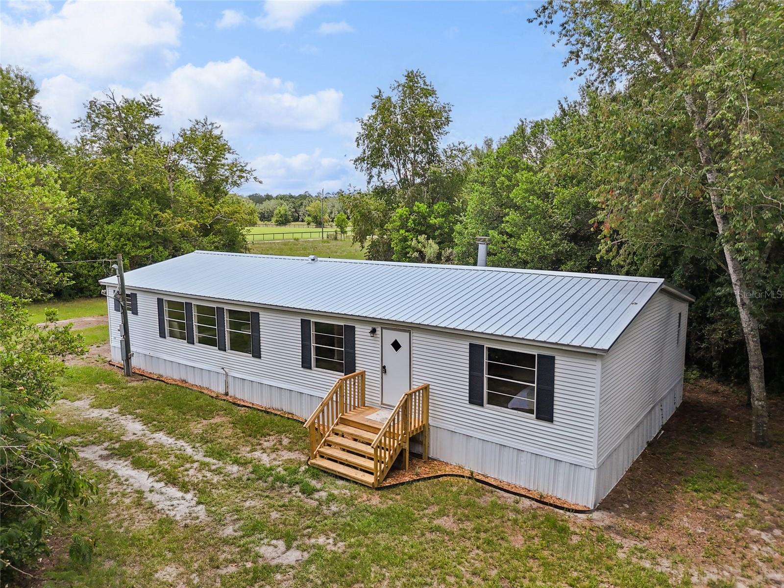 Completely updated home on 10.21 acres in Bell, FL! Enjoy peace and privacy with plenty of room for outdoor living. This property features a brand new metal roof (2025), new HVAC (2025), and a new well. Inside you’ll find a fully renovated kitchen and bathrooms, fresh paint, new flooring, and new skirting. The septic was inspected and passed in 2025, offering peace of mind for years ahead. The open floor plan provides comfortable living space, while the expansive acreage is ideal for gardening, recreation, or future projects. Located in Gilchrist County, this home combines modern updates with country living just a short drive to the Suwannee River. Move-in ready and set on a beautiful large lot!