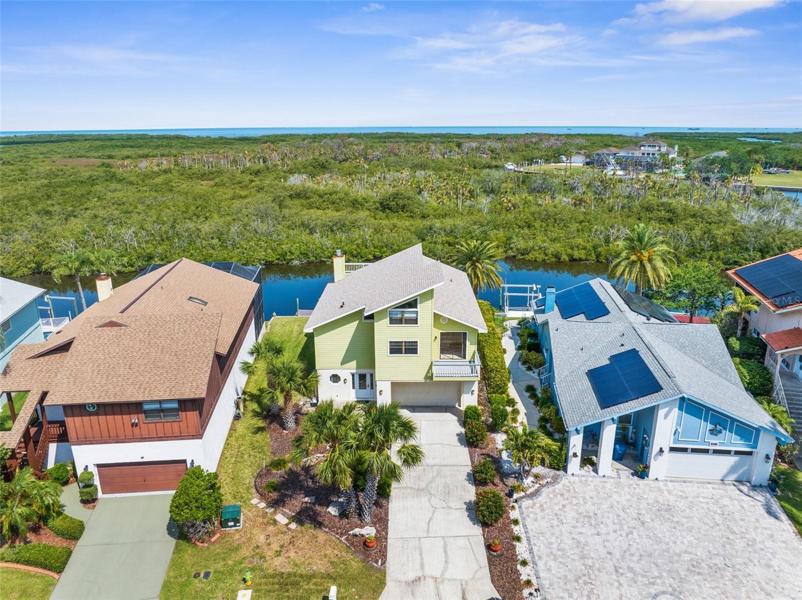 Waterfront Luxury with Peace of Mind – New Roof January 2025! This elevated waterfront retreat sits 14 feet above sea level, offering stunning Gulf views and protection from recent storms. Thoughtfully updated, it features a brand-new roof (2025), new HVAC system (2022), hot water heater (2018), and a 10,000 lb boat lift with electric (2018)—ideal for serious boaters. The home blends style and function with Hardie board siding, remodeled bathrooms, and multiple balconies and covered porches—both screened and open-air—perfect for entertaining or unwinding. The second level showcases a spacious great room with vaulted 17' ceilings, a cozy wood-burning fireplace, and a gourmet kitchen with wood cabinetry and granite countertops. The adjacent breakfast room opens to a shared balcony, creating a seamless indoor-outdoor flow. Three bedrooms open onto patio decks, two with private balconies. A fourth bedroom or bonus room connects to a third-floor balcony via a charming walkway. Outside, the expansive backyard deck is a front-row seat to dolphins, manatees, and Gulf sunsets. Located in an amenity-rich community with access to a private boat ramp, floating dock, clubhouse, tennis courts, pool & spa, and membership to the Gulf Harbors Private Beach Club. Just minutes from top-rated restaurants, shopping, and entertainment. Don’t miss this rare chance to own a stunning, move-in-ready waterfront oasis!