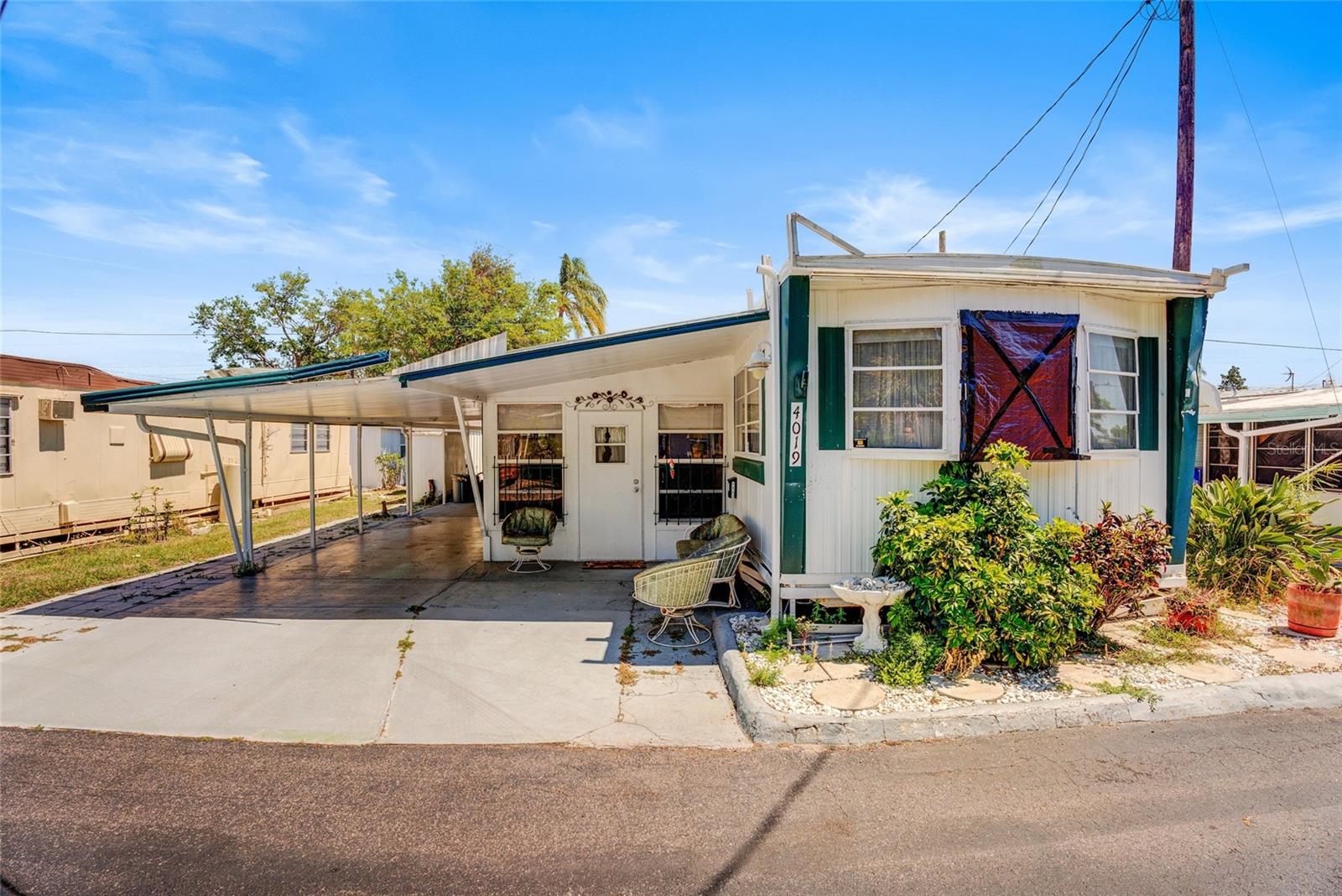Welcome to Citrus Grove Estates, a quaint 55+ cooperative with a wonderful location in Bradenton. Located just off US 301 and US 41, this community is close to many shops and restaurants! Only 30 minutes to beautiful Anna Maria Island! This home is perfect for either full time residence or as a snowbird! Minimal yard maintenance, with no shortage of parking space and concrete! The carport is huge, and comfortably fits two vehicles! When you step inside, you'll find the Florida room, with a second bedroom, and half bathroom! There is an indoor washer/dryer in the half bathroom as well! Inside the main house, the main living space is open, with the living room, dining room, and kitchen flowing together into one great room. Here you will also find a full bathroom, and the primary bedroom in the back of the home. Floors are SOLID. The roof-over was taken off during the hurricanes, but the main roof stayed in tact, with no leaks! The only other damage was to one of the windows in the front of the home that can be replaced. Because it was a roof-over, there IS a roof currently on the home, so it can be moved into immediately while a new roof is put on! The home is being sold fully furnished and turnkey! Citrus Grove Estates is a GATED community with plenty of amenities, including: shuffleboard courts, a clubhouse, and boccee court. There is always something to do, with plenty of activities and events scheduled in the park. Please keep in mind that this is a 55+ community and the park requires approval. There are also pet restrictions in the park. The monthly fee is normally $210, but there is an extra $100 per month special assessment for the remainder of the year to assist with hurricane repairs in the park.
