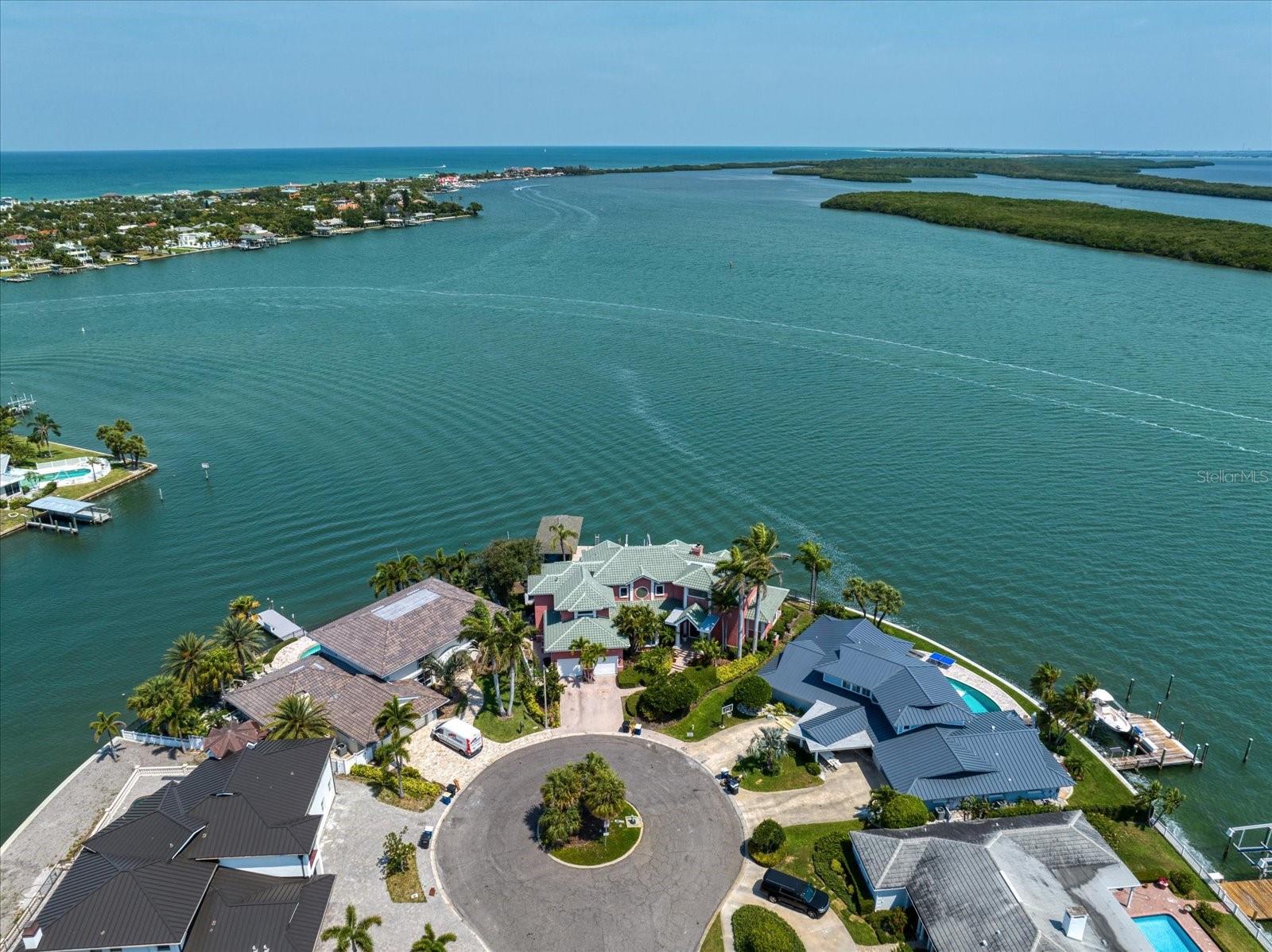 Indulge in the splendor of this exquisite waterfront estate, gracefully situated on a secluded cul-de-sac in the coveted waterfront community of Island Estates. Offering an impressive 166 feet of sea wall, this remarkable property presents unobstructed panoramic views of the open water and protected Moonshine Island. A newly unveiled gem in the market, this estate was meticulously crafted in 1995, with utmost attention given to its floor plan and design, showcasing an array of modern amenities. Crafted by esteemed 'Monogram' builders, this single-owner residence boasts five bedrooms, four and a half bathrooms, an office, a game room, a bonus room (or additional bedroom), and a two-car garage with high ceilings, ready to accommodate car lifts for two additional vehicles if desired. Graced by serene vistas of St. Joseph Sound, this haven boasts a private boat dock, complete with a covered 15K LB boat lift, a 6K LB boat lift, a deep water slip, and a decking area equipped with water and electrical hookups. Outdoor entertainment finds its perfect setting in the covered Lanai, complemented by a gas grill and overlooking a private heated Pebble Tec swimming pool. As you enter through the dramatic two-story foyer, the home unfolds graciously, revealing the Family Room and Living Room, both seamlessly connected to the captivating waterfront panoramas. Enjoy leisurely pursuits in the Billiards Room which can easily serve as an additional bedroom. Designed with the discerning chef in mind, the Gourmet Chef's kitchen showcases exquisite artistry and functionality with stainless steel appliances, gas cooktop, and brand new refrigerator. The Primary Bedroom Suite, adorned with 10-foot ceilings, offers a breathtaking expanse of open water vistas with a private balcony that invites relaxation, while the opulent master bathroom pampers with a steam shower, a garden tub, and a spacious walk-in closet with ample storage. Enhanced with surround sound, a surveillance system, central vacuum, storm shutters, and an alarm system, every detail has been thoughtfully considered. Nestled within the captivating beauty of the Gulf Coast, Island Estates stands as an idyllic community comprised of 550 single-family homes. This exclusive enclave offers a wealth of amenities, including charming shops, convenient banks, vibrant bars, and exquisite restaurants, ensuring a lifestyle of utmost comfort and convenience. Embraced by the shimmering waters of St. Joseph Sound, Island Estates residents enjoy breathtaking views and easy access to the pristine shores of Clearwater Beach. Renowned as the number one rated beach in the United States, Clearwater Beach entices visitors and residents alike with its powdery white sands, turquoise waters, and a myriad of recreational activities. Whether indulging in sun-kissed relaxation or partaking in thrilling water sports, the allure of Island Estates and Clearwater Beach is simply irresistible.