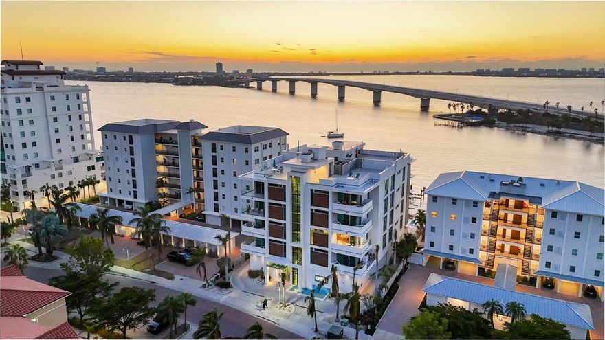 Waterfront living with boat lift in downtown Sarasota! ONE88, an exclusive boutique midrise directly on Sarasota Bay, offering a luxurious and serene lifestyle. This sought-after residence combines modern elegance with breathtaking waterfront views. Your private entrance, accessed by a secure elevator, opens to a spacious hallway ideal for showcasing your favorite art pieces. From here, the expansive living area unfolds, featuring soaring 10-foot ceilings and a wall of floor-to-ceiling retractable hurricane-impact glass doors that seamlessly blend the open-concept interior with the stunning 575-square-foot balcony. Whether hosting guests or enjoying quiet moments, the outdoor space provides the ideal setting for entertaining while taking in unforgettable sunsets. The chef’s kitchen is a masterpiece, equipped with top-tier Thermador appliances, a large center island for gatherings, a butler's pantry and a wet bar complete with a wine storage refrigerator. This gourmet space is designed for grand entertaining and intimate meals, all while offering panoramic 180-degree views of Sarasota Bay. The serene primary bedroom suite is a retreat, featuring glass sliders that lead to your private 254-square-foot patio, ideal for sipping morning coffee or stargazing before bed. The spa-inspired primary bath boasts a double vanity, a walk-in shower, a soaking tub, a makeup vanity, and a custom closet offering ample storage and space for your wardrobe. Two en-suite guest bedrooms are designed with convenience and comfort in mind, each featuring built-in closets and en-suite baths with walk-in glass showers. Throughout the home, electric shades ensure privacy and light control, adapting to your needs in every room. Enjoy stunning bay views from the paver pool deck, which includes a 15-by-50-foot pool, a gas firepit, a pool bath/shower, and direct access to the boat dock. The included dock lift can accommodate a boat up to 22,000 pounds with a 15-by-36-foot slip, offering easy access to the water for boating enthusiasts. The garage is nothing short of extraordinary, with space for two vehicles, an additional lift for a third car, and your private, air-conditioned storage unit. Additional amenities include a bike storage area and a car vacuum station for added convenience. The location of this condominium provides immediate access to the city’s vibrant cultural attractions, shopping, dining and galleries, all while maintaining a sense of privacy and tranquility. This is your opportunity to own an exceptional waterfront property in one of Sarasota's desirable locations.