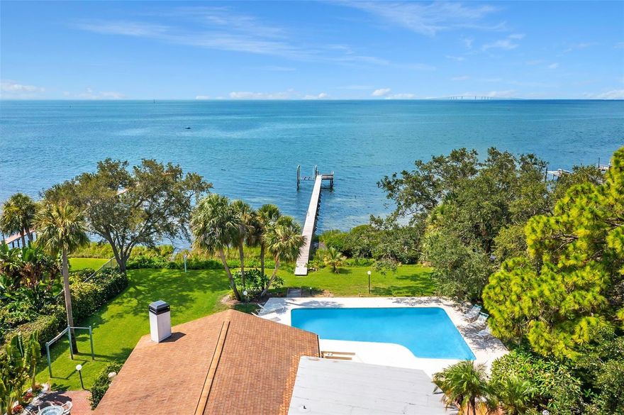 Introducing this Spectacular Tampa Bay Skyway Estate.  This property is a unique waterfront retreat with 115 Feet of open-water frontage and just around 1/2 acre of land.  This exceptional property offers a breathtaking 180-degree panorama of open waters, encompassing the southern, eastern, and western horizons. Revel in unobstructed views of the iconic Sunshine Skyway Bridge, complete with its captivating nightly light displays, and witness the graceful passage of cruise ships in and out of the Port of Tampa Bay. As the owner of this home, you can delight in the sight of marine life from your private dock and boardwalk, with frequent visits from dolphins, snook, redfish, and more.

Situated in the highly sought-after Pink Streets neighborhood, this stunning mid-century gem boasts four bedrooms, an office/optional fifth bedroom, three bathrooms, a spacious living room, a generously sized family room featuring a fireplace, an open kitchen with meticulously crafted teak cabinets, an inviting open floor plan, and pocket hideaway slider doors that seamlessly blend indoor and outdoor living.

Additional features include a large 24x40 in-ground saltwater swimming pool, oversized two-car garage, outdoor shower, multiple outdoor entertaining areas, a 400ft boardwalk and dock, a 10,000 lb boat lift, and 115ft of water frontage.

This home may also be purchased with the adjacent vacant lot, for a combined total of just over 1acre of waterfront land.  The adjacent lot has an additional 95 ft of waterfront and is currently for sale.