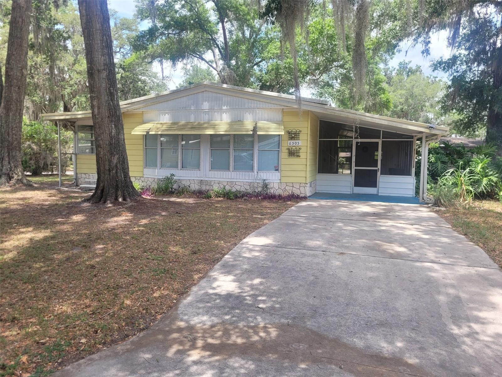 This cozy mobile home sits on a corner lot and features 2 bedrooms and 2 bathrooms. The current owner has made some updates, including new carpet in the living room and both bedrooms, and tile flooring in the kitchen. There’s a wood-burning fireplace in the living area for added charm.
The home also has an enclosed patio on one side and a covered breezeway on the other, where you’ll find the laundry area. A storage shed is included for extra space.
