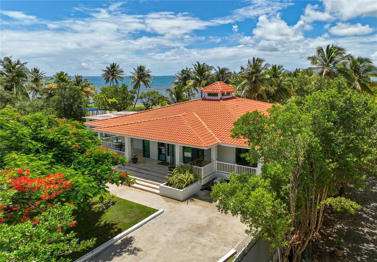 Enjoy beachfront living at its finest with this private retreat in Rio Grande. Boasting approx. 1,880 interior Sq. Ft. and approx. 2,997 exterior Sq. Ft., the expansive home sits on over a quarter of an acre of fenced and manicured land. Affording unparalleled privacy, the residence also showcases an inviting contemporary design with unique features such as vaulted ceilings with up to 18’3’’ heights and a skylight in the open-concept living/dining area that connects to the fully-equipped galley kitchen with center island. Both bedrooms are ensuite and lead out to the oversized covered/uncovered wrap around patio with oceanview pool and separate powder room. The master suite generously includes a walk-in closet with custom made built-in cabinets. A dedicated laundry room, storage area and enclosed driveway with space for four cars round out this exceptional offering. Rio Grande is positioned on Puerto Rico's scenic eastern coast, home to multiple highly-acclaimed resorts and the El Yunque Rainforest, one of the island’s most precious landmarks and an ecological marvel. The region is also a 45-minute drive away from the largest marina in the Caribbean and San Juan, Puerto Rico’s vibrant metropolitan epicenter. Embrace a serene lifestyle by the beach while still being within close proximity to all of the amenities of the city.