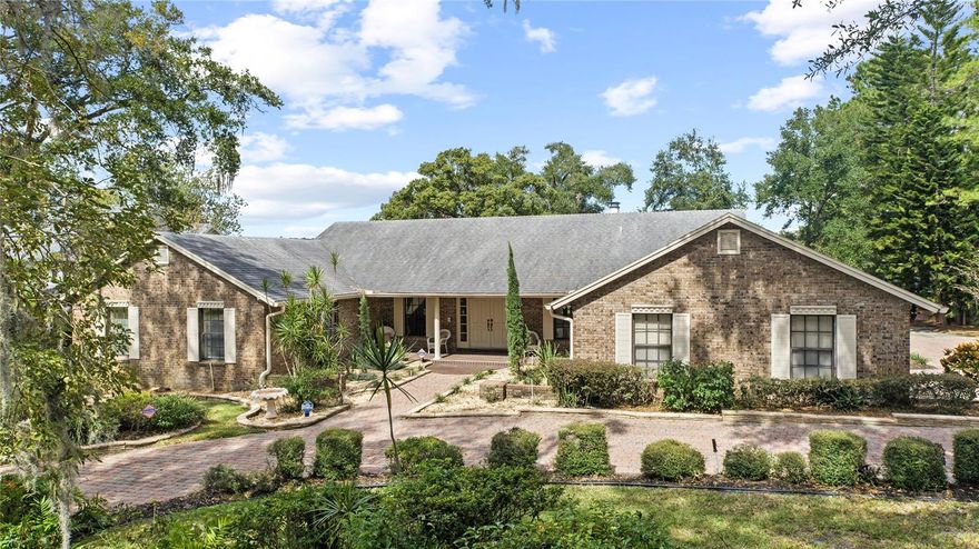 Welcome to a rare opportunity on the shores of Lake Sybelia, one of Maitland’s most desirable recreational lakes. This custom, one-owner home offers 3,754 square feet of thoughtfully designed living space where timeless craftsmanship meets peaceful waterfront living.
A brick-paved horseshoe driveway and inviting front porch set the tone. Inside, rich wood floors, vaulted wood ceilings in the living and family rooms, two fireplaces, and custom built-ins showcase quality rarely found today.
The spacious layout features four bedrooms and 3.5 baths, including two primary suites ideal for multi-generational living. Generous walk-in closets and a blend of wood, tile, and carpet add comfort and function. A new A/C (Oct 2025) and a 6.5-year-old roof provide peace of mind. Living areas open to a bright rear sunroom with tranquil lake views. Whether you’re entertaining by the fire, enjoying coffee on the porch, or heading out onto the lake, this property delivers the Florida lifestyle at its finest.