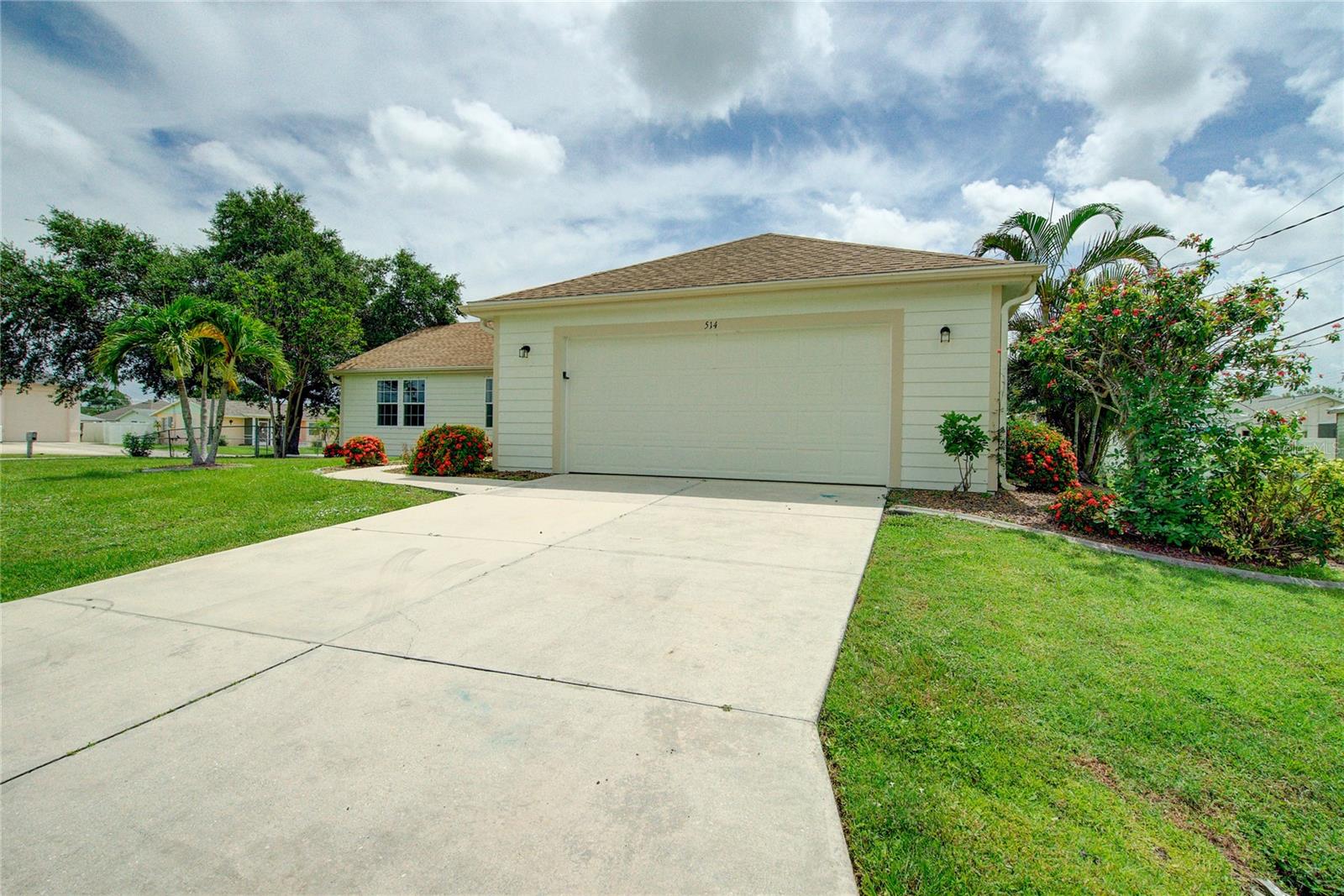 Situated on an expansive 80x125 corner lot, this well-maintained residence offers a split floorplan designed for privacy and functionality. The open living and dining areas feature vaulted ceilings and sliding glass doors that enhance natural light throughout the interior. The kitchen, with its breakfast bar, opens directly into the main living area, creating an ideal space for everyday living. Interior highlights include an inside laundry area and dual sinks in the primary bathroom. With no carpet throughout, the home is easy to maintain. The oversized 24x23 garage adds convenience and storage flexibility. Recent improvements include a new roof in 2021 and an air conditioning system installed in 2019. Located with quick access to I-75, the property is approximately 10 minutes from Port Charlotte Town Center, 15 minutes to the SunSeeker Resort and Charlotte Harbor waterfront, 20 minutes to both Downtown Punta Gorda and Punta Gorda Airport, and about 30 minutes to the Gulf beaches.