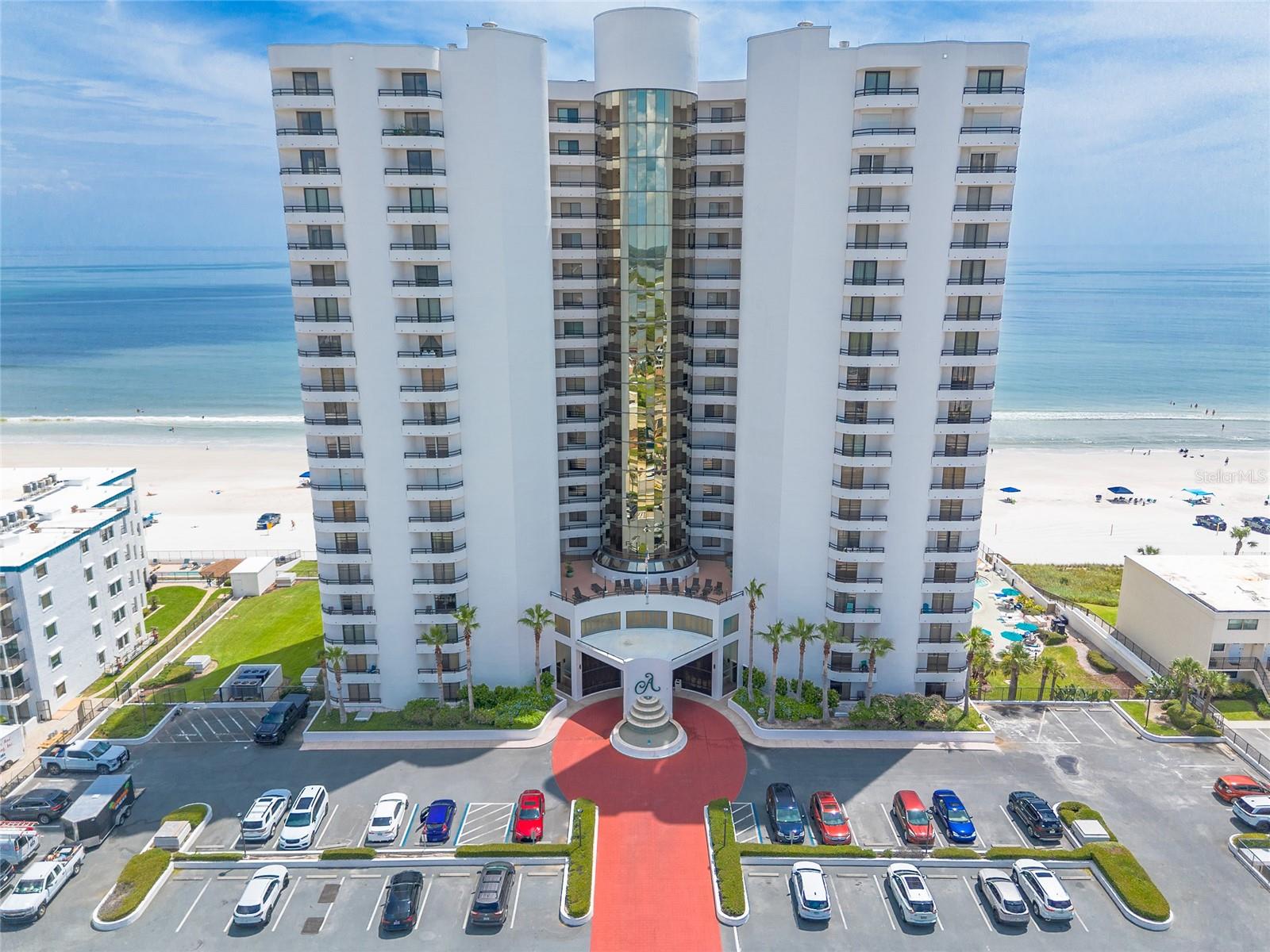 Welcome to The Ashley, one of the most prestigious and architecturally distinctive oceanfront condominiums in Daytona Beach Shores. Renowned for its striking design, exceptional financial stability, meticulous maintenance, and the attentive service of its dedicated live-in managers, The Ashley offers a lifestyle of ease, comfort, and coastal elegance. This highly sought-after end unit is one of the largest floor plans in the building, spanning nearly 1,600 square feet and stretching from the east to west sides of the tower, providing uninterrupted panoramic views of both the Atlantic Ocean and the Intracoastal Waterway. Perched on the 12th floor, it delivers breathtaking sunrise and sunset vistas from its expansive 50-foot-long private balcony, allowing you to enjoy both ocean breezes and riverfront glow. Inside, the unit has been tastefully updated with porcelain tile flooring, brand-new carpeting, and a 2020 HVAC system to ensure energy-efficient, year-round comfort. The flowing layout features an open living and dining area filled with natural light, a well-appointed kitchen, and spacious bedroomsall designed to maximize views and comfort. The Ashley offers a comprehensive suite of resort-style amenities designed for relaxation and recreation, including a heated oceanfront pool, indoor spa and saunas, fitness center, game room, bicycle storage rooms, BBQ and picnic area, and an expansive rooftop sun deck. The top-floor community room, complete with floor-to-ceiling windows, offers breathtaking 360-degree views, making it an ideal space for hosting gatherings or simply unwinding. Additional features include two unassigned underground parking spaces and a private storage cage, perfect for storing your beach gear and seasonal items. The Ashley also allows for short-term rentals (minimum one week), making this a great option for both personal use and investment potential. This is a rare opportunity to own a beautifully maintained, direct oceanfront end unit in one of the area's most respected and desirable condominium communities. Experience the very best of coastal living, schedule your private showing today! All information deemed accurate but cannot be guaranteed.
