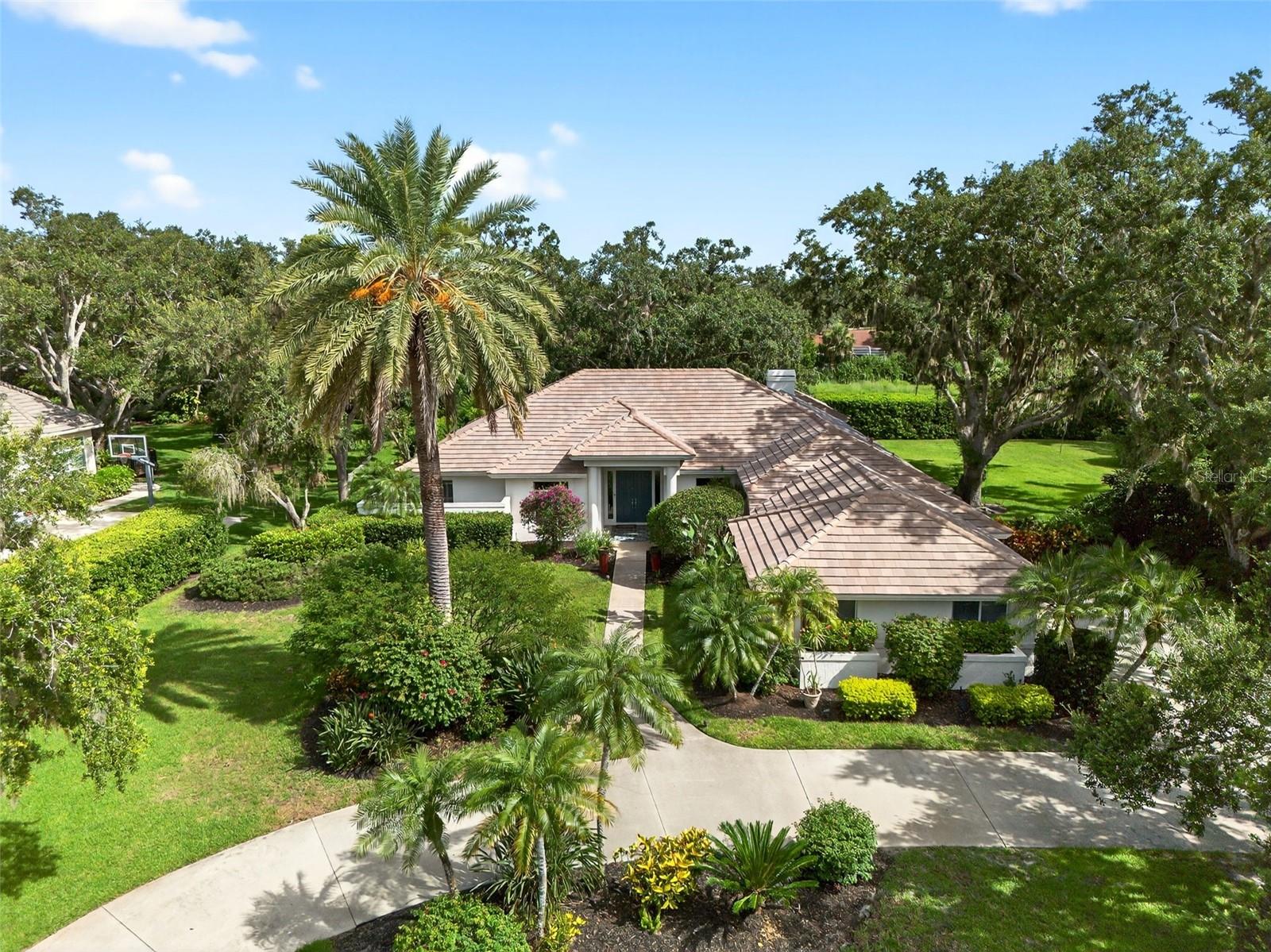 Prepare to fall in love with this exquisite four-bedroom, four-bath, three-car garage, pool residence on a generous, almost-acre, lot in Sarasota’s Laurel Oak Estates. Entering the driveway, you will instantly appreciate the *Brand new* flat tile roof installed using the Hybrid system for attaching tiles involves 2 Muro Coated Tile Screws and Tilebond tile adhesive on the tile ensuring peace of mind for decades to come. As you exit your vehicle, the property's allure begins to unfold with the lush, mature landscaping, where majestic Oaks provide a serene canopy of shade. A convenient circular driveway welcomes you, leading to a grand double-door entrance that sets the stage for what lies beyond in 3,546 square feet under air. Upon stepping in, the elegance continues with luxurious Italian tile flooring and vaulted ceilings that guide you throughout the home. Your eyes are naturally drawn to the spacious screened-in lanai and the inviting gas-heated pool with connected spa, promising endless relaxation, and entertainment. The heart of the home Kraftmaid kitchen features new Bosch appliances and instant hot water dispenser, soft-close drawers and granite countertop extending seamlessly your outdoor dining experience through the pass-through window. The primary en-suite is a sanctuary of modern elegance, featuring ample closet space, completely updated and redesigned bath with a walk-in shower, double vanity with soft close drawers and standalone soaking tub. Unique fourth bedroom stands out with its versatility, serving as an ideal home office or a private Casita / mother-in-law suite, complete with its own separate outdoor entrance. This space offers privacy and independence for extended family or work-from-home professionals. The residence has been completely replumbed in November 2024 with durable, long-lasting PEX piping. The home has new solid wood doors throughout, and a new air conditioner installed in May 2025. The fully fenced in backyard and separate side-yard dog-run off the lanai is a sanctuary for your pets and provides pet owners with a level of convenience not often found in gated golf course communities. This home is not just a residence, it is a lifestyle choice, where every detail has been considered to offer luxury and functionality. Embrace this lifestyle, where comfort meets elegance, and where every day feels like a retreat in your private paradise. Laurel Oak Estates is a beautifully maintained gated community integrated with the Laurel Oak Country Club. Sarasota's premier private Golf and Country Club, featuring two 18-hole championship golf courses, and 12 Har-Tru tennis courts all lighted for evening play. A premier swimming facility features a six-lane, junior Olympic-size heated swimming pool for lap work or social swimming. Imagine weddings or exclusive events where nature and elegance come together at the 45,000-square-foot clubhouse within eight hundred acres of peace and serenity.
