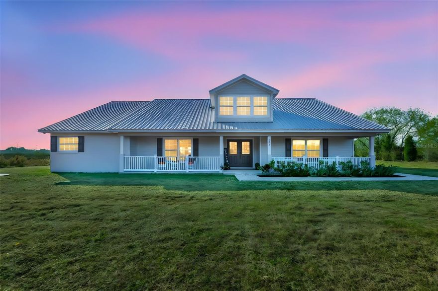 Welcome to your private Florida homestead at 603 Half Mile Road in Plant City. Set on just over 5 acres of agriculturally zoned land, this custom-built 4-bedroom, 2-bath home offers space, privacy, and flexibility—ideal for those seeking room to live, work, and grow. Set well back from the road, a long private driveway winds through established oak trees, creating a peaceful arrival that feels worlds away from the everyday. Along the drive, you’ll pass a metal building perfect for equipment storage, hobbies, or housing recreational toys before reaching the home. A wide front porch invites you in—perfect for morning coffee or evening sunsets. Inside, double entry doors open to a spacious great room that flows seamlessly into the kitchen, creating a central gathering space designed for both entertaining and daily living. The kitchen features custom cabinetry, granite countertops, and an open layout that keeps everyone connected. Just off the main living area is a versatile bonus room with French doors and its own exterior entrance—ideal for a home office, flex space, studio, or private guest area. The home’s split-bedroom design offers excellent privacy, with the owner’s retreat tucked away on one side of the home featuring two walk-in closets and a spa-like en suite with a soaking tub, walk-in shower, and French doors that open directly to the back lanai, while three additional bedrooms and a full bath are thoughtfully positioned on the opposite side of the home. Zoned agricultural single family, the property allows for a variety of uses, including space for farm animals, gardens, hobby farming, and potential for an additional dwelling unit or guest home. Additional highlights include a durable metal roof and fresh interior and exterior paint. While the property offers the feel of a secluded country retreat, growth continues to expand throughout the surrounding area, providing long-term opportunity while maintaining convenient access to Tampa, Lakeland, and surrounding areas—a rare opportunity to own usable acreage where privacy today meets potential for tomorrow.