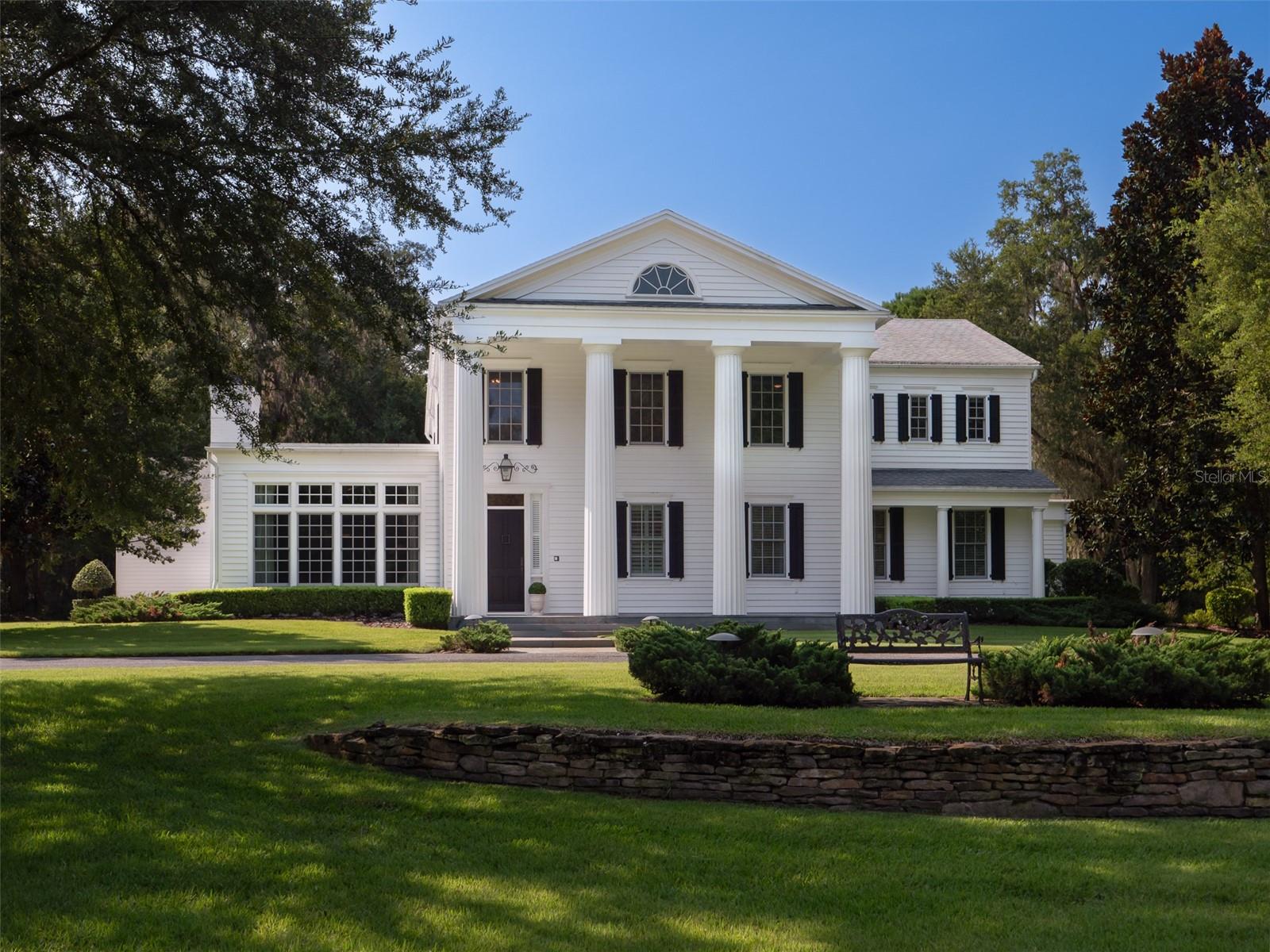 ***** Luxury 10.74-acre Estate *****
A flawless integration of timeless architectural charm and state-of-the-art amenities, effortlessly combining elegance with modern luxury—a perfect fusion of tradition and sophistication. From its stately grand columns and intricate molding to the expansive verandas offering sweeping views of the meticulously landscaped grounds, every detail reflects a perfect blend of past and present. Situated within the exclusive gated Wyndsong enclave, this exceptional estate features a stunning home on 5.01-acres, along with an adjacent 5.73-acre parcel. A private gated entrance welcomes you, setting the stage for a residence that exudes warmth, elegance, and timeless charm. ~~
Step inside to an impressive foyer that sets the tone for the home's grandeur. Throughout the residence, you'll find a balance of refined elegance and relaxed comfort, designed for both luxurious living and effortless entertaining. The kitchen is a chef’s dream, meticulously crafted with premium features and thoughtful touches to meet the highest expectations. ~~
The lower level offers two generously proportioned family rooms, each with its distinct ambiance. The first exudes rich charm and warmth, ideal for intimate gatherings, while the second is bathed in natural light, creating a bright and airy space that perfectly complements the surrounding scenery. ~~
The first-floor primary suite is a private retreat, providing an exceptional sanctuary of comfort and style. Upstairs, three spacious ensuite bedrooms and an additional large gathering area ensure ample space for everyone. For added convenience, dual laundry areas are thoughtfully located on each floor. ~~
Outdoor living is equally impressive, with multiple dining and entertainment spaces that flow seamlessly to the pool, summer kitchen, and beautifully maintained grounds. Whether relaxing poolside, hosting a gathering, or enjoying a quiet moment in the open-air spaces, the outdoor elements enhance the estate's sense of flexibility and luxury. ~~
Located in one of Gainesville's most desirable areas, this estate combines the tranquility of wide-open spaces with proximity to top schools, shopping, dining, parks, and recreation. Just minutes from The University of Florida, UF Health/Shands, HCAFHC, Santa Fe College, the Town of Tioga, and Jonesville Park, this home offers an unparalleled lifestyle where timeless elegance meets modern convenience.