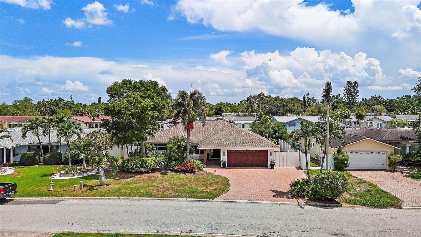 Join the Ponderosa Shores renaissance. This home is an open canvas to renovate as you please, or join your next-door neighbors and raze the home and build your waterfront dream home on this spectacular waterfront lot that has a newer 81’ seawall with 3’ cap and 300 sf custom dock with two boat lifts. This home is just a short 10-minute drive to vibrant downtown St. Pete, a 10-minute idle to Tampa Bay and only a few paddle strokes to protected Placido Bayou Mangrove Preserve where you can explore the mangrove trails by kayak or paddle board. Watch dolphins and manatees swim around and under your dock while you enjoy the sun set behind the mangrove preserve. The newer 40th Avenue bridge has a 13.2’ vertical clearance at mean hightide to accommodate most non-flybridge vessels. This beautiful waterfront home flooded during Hurricane Helene and was fully remediated with 4’ drywall cuts throughout the entire home. All flooring with the exception of the two bathrooms was removed and is currently bare concrete slab floors. Until Hurricane Helene in September, 2024 this home had never flooded since its construction in 1972. Protected waterfront with superior all-block construction; 3 bedrooms, 2 bathrooms with open concept, split floor plan;1,789 heated sq/ft, 2,535 total square feet; 2-car garage with hurricane impact garage door and Smart Home garage door opener, paddle board and fishing rod storage; Lot size: 7,797 sq/ft (0.17 acres MOL. 81’ wide x 102’ deep MOL); Smart Home features Vivint security/fire alarm system; 81' newer seawall with 3’ cap (Gulf Coast Marine Construction); Two Lifts: 10,000 lb boat lift and 4,500 lb double jet ski/boat lift; Large Custom Dock: 300 sq/ft (25’ x 12’ w/ 3’ step down platform for easy launching of kayaks and paddleboards) with superior Azek composite cool decking with wrap around trim, high density polyethylene wrapped dock pilings, electric and water; Expansive outdoor deck: 660 sq/ft; 8-person hot tub (hot tub damaged by flooding); Roof: 2012 – GAF Timberline 30-year upgraded shingle with roof membrane (assumable warranty) and updated soffits and facia (no damage experienced from hurricanes); Newer HVAC 2021: Trane, 16 Seer (4 ton) Heat Pump with UV Light system for improved air quality. Warranty: 10-year warranty for Compressor (Compressor damaged by flooding); 10 years coil; 10 years parts; 22kw Whole House Generac Generator (2022) with transferable warranty; Designer lighting throughout; Windows: updated (sliding doors and some windows damaged by flooding); Ceiling fans throughout; Covered Lanai and entrance way improved with hand-stained wood slats on ceiling; Exterior painted: 2022; New Samsung washer and dryer, front loading – 2024 (Never used. Washer might be damaged by flooding); Water main line replaced (2006); Additional and plentiful attic storage with high pitched roof; Expanded paver driveway with 3-car parking; Irrigation system (reclaimed water) and upgraded gutter/drainage system; Windster stainless steel vent hood in kitchen; Skylight (upgraded tempered glass); LED recessed ceiling lighting; Neighborhood has all underground utilities including cable, natural gas and electric (no unsightly power poles and power lines); Primary Bedroom and Ensuite Bath: Overlooking water and adjacent to back lanai; Walk-in closet; Separate water closet; Dual shower heads plus rain shower head; and Dual Vanity Plumbing; Guest bath: Dual Vanity Plumbing; New Travertine.