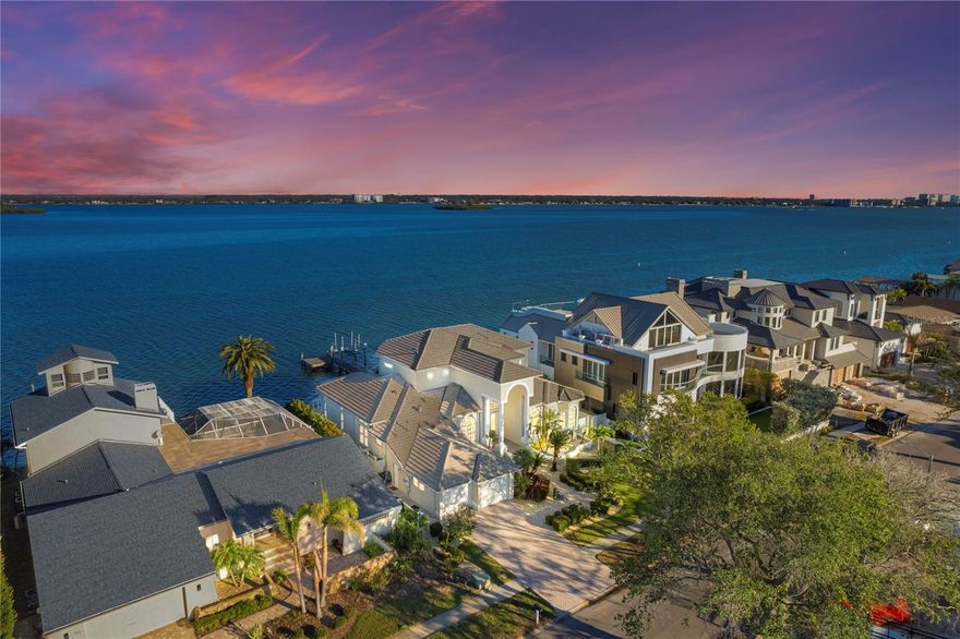 Island Lifestyle | The Epitome of Luxury Living at Island Estates, where Sophistication meets Serenity in this Stunning Intracoastal Waterfront Home.  Positioned on the Leeward Isle of Clearwater Beach, this Beautiful 5 Bedroom, 5 Bathroom Home is showered in both Sunlight and Gulf Breezes, creating a Boater's Paradise for any Island Lifestyle enthusiast.  Situated with Deep Water Access directly on the Intracoastal with wide views of Dunedin and Clearwater, this home enjoys front row seats for Christmas Boat Parades and Fourth of July Fireworks and Festivities.  At 11ft Elevation, this Safe Haven has never had water intrusion and comes complete with a Gas Powered Generator to run the household electricity and the 12,000lb Boat Lift.  Welcome your guests through a breathtaking foyer with soaring ceilings and uniform flooring, leading into an open-concept living space bathed in natural light with inviting water views, complete with a saltwater aquarium.  The expansive master suite offers a private escape with a private office nook with direct water views and a spa-like bathroom featuring a standalone soaking tub, dual vanities, and a walk-in closet designed for a fashion-forward lifestyle. Step outside to your very own retreat with a sparkling in-ground pebble-tec heated pool & spa, a covered patio for al fresco dining, and lush landscaping that ensures privacy and tranquility. Composite Dock with wrapped pilings, running water and electricity, along with a solid concrete seawall with excellent condition capping and sturdy tiebacks.  Equipped with 3 AC Units and a 22kv Gas Generator to run household, Storm Shutters (some electric controlled) and Impact Glass, Gas Fireplace, Wet Bar, Central Vac, Tankless Water Heater with a Second Water Heater in Master Bath for immediate warmth, Walk-in Tub Downstairs, Impact Garage Doors, New Pool pump, Remote Bluetooth Heater, & Filter, as well as termite warranty w regular precautionary treatment.
