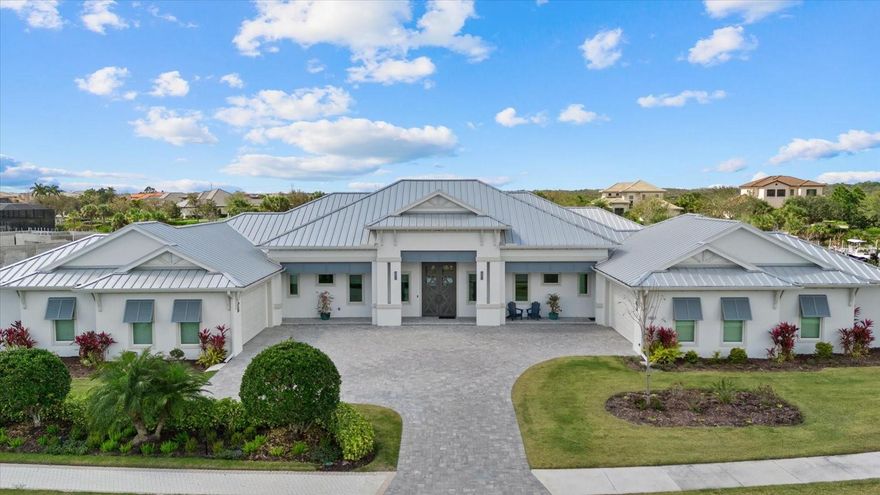 This extraordinary custom waterfront residence with a saltwater pool & spa in the Islands on the Manatee River blends luxury design, cutting-edge technology & direct boating access to the Gulf with no locks. Set on a private, nearly acre homesite, the impressive 131-foot-wide estate, completed in December 2024, offers 4,200 square feet of luxurious living space - with 7,200 total square feet under roof, including an expansive 8-car garage & large covered lanai space perfect for entertaining & enjoying the stunning water views. The home features 185 feet of waterfront living & a private dock with a 20,000-pound lift, making it a dream property for boating enthusiasts. 

Inside, the thoughtfully designed open-concept floor plan includes 4 bedrooms with en-suite baths, den/office, bonus room, half bathroom & storage room, all finished with exceptional craftsmanship including 11-foot ceilings, upgraded LVP flooring throughout, 8-foot solid wood doors with extra wide openings, crown molding, vaulted ceilings, wood accented ceilings, impact-resistant Anderson windows & PGT doors.

The chef’s kitchen is the centerpiece of the home, showcasing Thermador appliances, a built-in double oven, gas range with griddle & downdraft vent, 60-inch Dacor column refrigerator/freezer, 42-inch shaker-style wood cabinetry with upper cabinets, large quartz island, farmhouse sink, hidden walk-in pantry, coffee station, a wet bar with wine refrigerator & additional sink. The adjoining living room features 14-foot vaulted ceilings, custom built-ins & a dramatic 24-by-10-foot pocket sliding glass door that opens seamlessly to the outdoor living area.

Designed for true Florida living, the expansive lanai offers nearly 1,000 square feet of covered entertaining space, highlighted by a pool/spa with gas heater, panoramic screen enclosure, upgraded pavers, a fully equipped outdoor kitchen with Blaze grill & cooktop. Additional outdoor spaces include a fire pit, patio & beautifully landscaped yard. A spacious bonus room with zero-corner sliding impact glass doors, surround sound & water views provides the perfect space for entertaining.

The luxurious primary suite features French doors to the lanai, large dual walk-in closets & a spa-inspired bathroom with freestanding tub, quartz vanities, walk-in shower with rain head & dual showerheads. 

Built with high-end systems & modern efficiency, the home includes two Navien tankless gas water heaters, a 500-gallon propane tank, whole-house water filtration, reverse osmosis drinking water system, Cat6 wiring throughout, multi-zone surround sound, security system with 4K cameras, powered Roman shades, Wi-Fi irrigation from a private well & automated landscape lighting.

The oversized eight-car garage offers exceptional flexibility for car enthusiasts or storage, featuring epoxy floors, insulated hurricane-rated doors, spray foam attic insulation, Wi-Fi LiftMaster openers with cameras, EV charging & rear garage access to the backyard.

Residents enjoy access to a community space with gym, great room, fire pit, bocce court, putting green & day dock. Optional golf memberships available at River Wilderness Golf & Country Club. Located 3 miles from Lakewood Ranch, with easy access to airports, shopping, dining & beaches.

This property offers a rare opportunity to enjoy custom luxury, modern efficiency & direct Gulf boating access. A full feature sheet is available detailing the extensive enhancements throughout.
