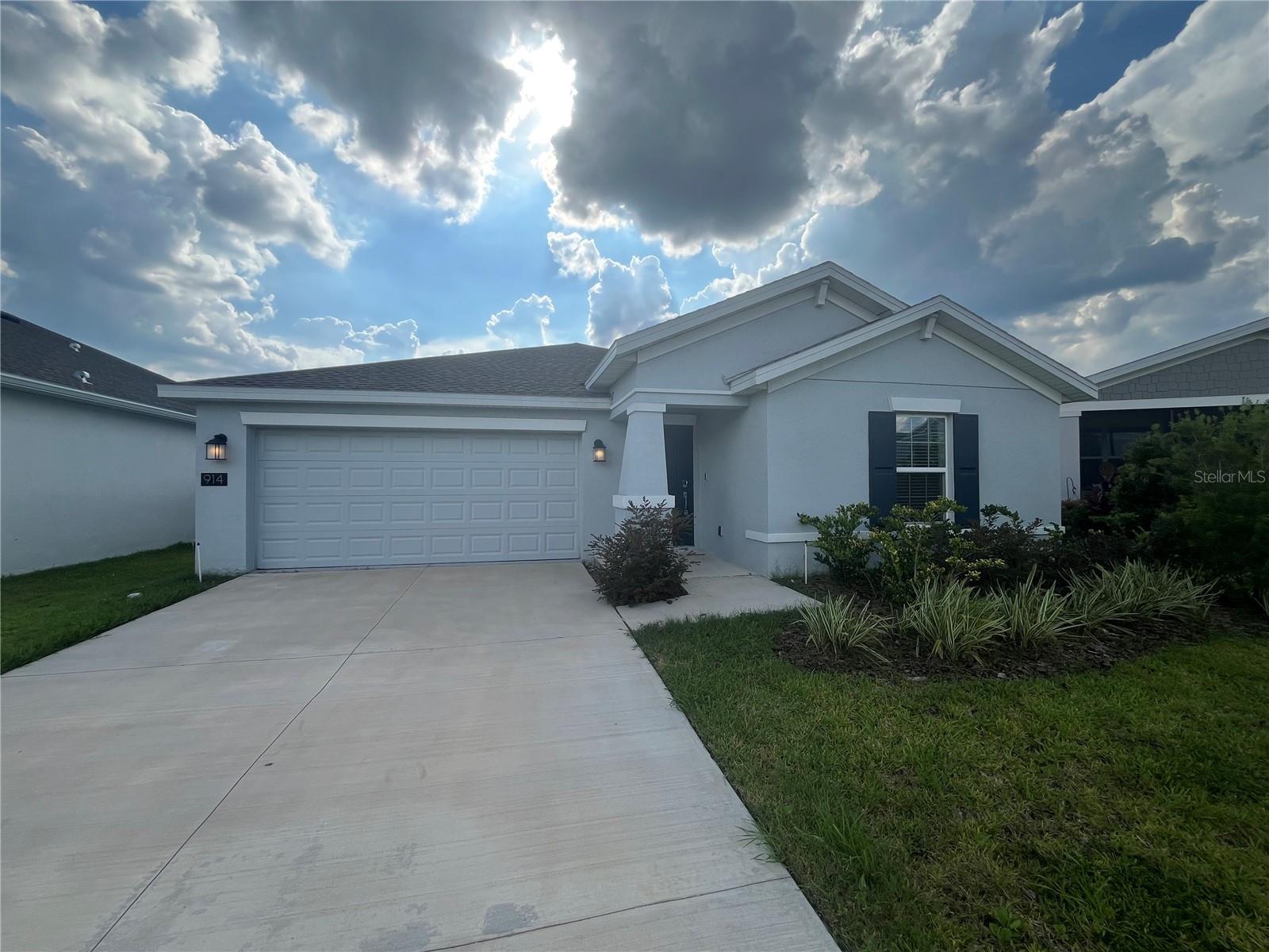 This beautifully designed single-family home, built in 2023, offers 1,555 square feet of modern living space in the desirable Inman Groves community of Winter Haven, Florida. Featuring three spacious bedrooms and two full bathrooms, the home boasts an open-concept layout with a bright and functional kitchen that includes solid surface countertops, stainless steel appliances, a walk-in pantry, and direct access to both the dining area and living room, making it ideal for entertaining. The primary suite includes a large walk-in closet and a private en-suite bathroom with dual sinks. Additional highlights include an interior laundry room, energy-efficient double-pane windows, and a central HVAC system enhanced by a fully integrated solar panel system that significantly reduces utility costs. The exterior offers a covered front porch, a back lanai, an attached two-car garage, and a professionally landscaped yard on a low-maintenance 5,837 square foot lot. Located just minutes from Legoland, major highways, shopping, dining, and local lakes, this move-in-ready home is the perfect blend of comfort, sustainability, and convenience in a peaceful, newly developed neighborhood.