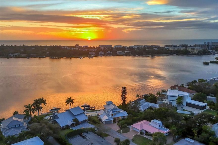 Experience the pinnacle of coastal luxury at 1601 Idle Lane, a stunning four-bedroom, 3.5-bath haven ideally positioned on Sarasota Bay near Siesta Key's south bridge. This meticulously remodeled residence redefines sophisticated living, inviting you into a welcoming yet expansive floorplan designed for embracing the quintessential Florida lifestyle and endless water and sunset views. The great room, boasting multiple seating areas and a bar with wine refrigerator and 10-foot walnut counter, sets the stage for effortless entertainment. Culinary adventures await in the well-appointed kitchen, equipped with top-tier Bosch appliances, an oversized island with quartz countertops and seating, and a custom-organized pantry accessed through barn doors. With light wood-look plank tile flooring, crown molding, and pocketing sliders seamlessly merging indoor and outdoor spaces, the main living areas exude comfort and functionality. Upstairs, discover a sanctuary within the primary suite, a serene retreat offering endless water vistas, complemented by a private third-floor loft, ideal for an office or sitting room complete with a built-in bar and beverage cooler. The primary retreat includes two walk-in closets and a spa-like bath. The second level also hosts a bonus room with access to a terrace featuring Trex® deck boards and breathtaking views. Three guest rooms on the main level, each with access to remodeled baths, and patio and deck areas, ensure privacy for all. Step outside to relish in the perfect outdoor haven, an inviting new pool with tanning shelf and spa, a travertine pool deck and patio, a summer kitchen with grill, refrigerator and granite countertop, a concrete fire pit and a professionally landscaped yard leading to a newer seawall and dock boasting a 14,000-pound boat lift. For added outdoor comfort, there is also a screened in patio area with upgraded flooring, privacy screens and sliding glass doors. Recent upgrades, including hurricane windows and doors, a sleek standing seam metal roof, an electric screen and custom metal railings throughout, reflect the home's meticulous attention to detail. With three new Lennox HVAC systems installed in November 2021, comfort is assured. Impeccable craftsmanship, mesmerizing views and thoughtful design converge to create an unparalleled coastal retreat, all while a short drive from Siesta Key's white sandy beaches and downtown Sarasota's vibrant offerings.