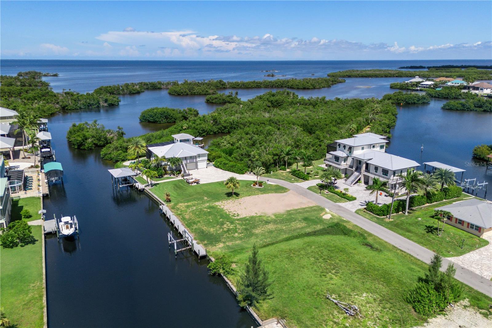 This is an exceptionally rare opportunity—just one lot in from the tip and only five minutes from the stunning waters of Charlotte Bay. No need to wait for a seawall; it’s already installed, along with a Captain’s Walk, boatlift, and electrical hookups. Even better, all the fill dirt is in place, so the lot is ready for your new build! The south-facing backyard ensures plenty of natural light, and the property features a manicured lawn and a paver driveway, as the lot was originally part of a three-lot parcel. Pirate Harbor is a welcoming boating and fishing community with a laid-back vibe that embraces golf carts and casual living. Enjoy effortless boat access to nearby islands such as Sanibel, Captiva, Boca Grande, Cabbage Key, Tarpon Point, and many more. Whether you’re spending the day cruising or fishing from your dock, you’ll regularly spot vibrant marine life, including dolphins and manatees, in this canal. Located in the thriving Punta Gorda area, Pirate Harbor offers easy access to downtown, Cape Coral, and Fort Myers. Why not embrace the pirate spirit and make this incredible community your home?