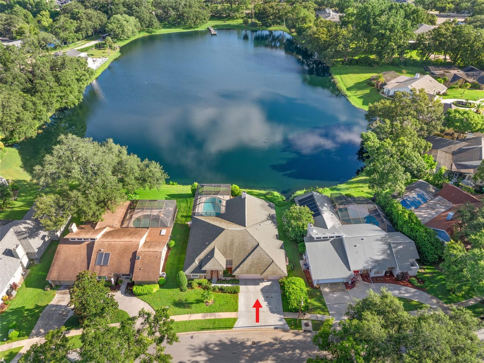 One or more photo(s) has been virtually staged. Welcome to your Florida dream home! This beautifully maintained 3-bedroom, 2-bath, 3-car garage residence in the highly sought-after Lake Valencia community is perfectly positioned on a tranquil lake with breathtaking water views and a screen-enclosed in-ground pool, offering the ultimate Florida lifestyle both indoors and out. The double-door front entry opens to a spacious formal living and dining room with soaring volume ceilings and direct access to the lanai. Enjoy stunning pool and lake views from the moment you step inside. The split-bedroom floor plan provides privacy and functionality. The primary suite is located opposite the guest bedrooms for added seclusion and features a double-door entry, French doors to the lanai with peaceful pool and lake views, an oversized walk-in closet, luxurious en suite bath with extended dual-sink vanity with ample storage, a deep Jacuzzi soaking tub, separate step-in shower, and private water closet making this suite an ideal oasis. Across the home, the open-concept kitchen and family room with lake views will be the perfect space for entertaining! Features include recessed lighting, breakfast bar, built-in desk area, pantry closet, cozy brick-front wood-burning fireplace with custom built-in shelving on both sides, wall of windows and doors that flood the space with natural light, and a breakfast nook that offers direct lanai access and tranquil views. Located off the family room are your secondary bedrooms and guest bath. Both bedrooms have spacious wall closets while the rear bedroom boasts beautiful lake views. The shared full hall bath has a tub/shower combo and the hall linen closet includes built-in shelving for convenience. The screened-in lanai has an expansive covered patio area—perfect for al fresco dining and lounging. The gorgeous in-ground pool has a peaceful lake backdrop and is ideal for entertaining or simply relaxing. Additional features include a 3-car garage with built-in cabinetry for extra storage, a laundry room off the kitchen with utility sink, extra storage cabinet, bonus storage closet and washer/dryer hookups. Engineered hardwood floors throughout with tile in kitchen and baths makes this home low maintenance and great for Florida living. Located just minutes from top-rated schools, beaches, shopping, dining, and parks, this Lake Valencia gem offers a rare blend of privacy, comfort, and convenience. Homes with this level of care, layout, and view are highly desirable—schedule your private showing today!