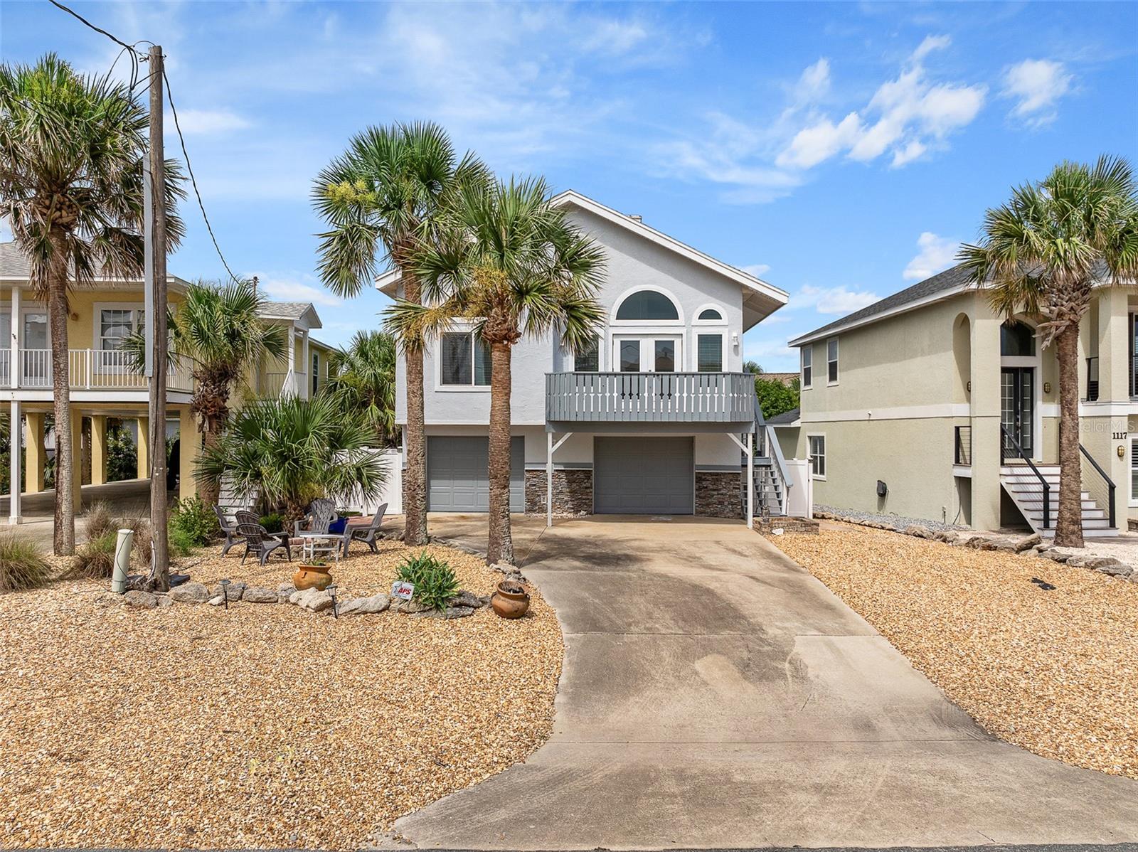 Welcome to 1115 N. Central Ave., Flagler Beach — a bright and spacious coastal escape just one block from the ocean, designed with family relaxation and flexibility in mind. Offering 2,675 square feet of living space, this 3-bedroom, 3-bathroom home is the perfect second home or vacation retreat. The heart of the home features a sun-drenched living area with large circular windows that flood the space with natural light, creating an inviting atmosphere for gathering and entertaining. Just off the living room, enjoy ocean breezes from the front-facing balcony, while the primary suite upstairs includes a large covered balcony, perfect for quiet mornings or winding down at the end of the day. An expansive upstairs loft offers tremendous flexibility—ideal as a playroom, home office, media room, or even a potential fourth bedroom. The home also includes a private in-law suite with its own bedroom, living area, and full kitchen, making it perfect for extended family stays or generating rental income. With a brand-new roof, two brand-new AC units, fresh paint inside and out, upgraded light fixtures and a location just moments from Flagler Beach’s shops, restaurants, and parks, this home is move-in ready and full of potential. Whether you’re hosting family beach getaways or building long-term memories, this property offers the ideal blend of comfort, style, and income opportunity.