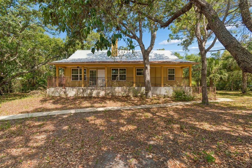 Nestled among mature trees on a peaceful half-acre lot, this cozy retreat in Homosassa offers the perfect blend of comfort, privacy, and modern construction. Built in 2019 and topped with a durable metal roof, this charming 2-bedroom, 2-bathroom home was designed for easy living while still feeling warm and inviting from the moment you arrive through the gated entry.

Inside, you’ll immediately notice the welcoming atmosphere created by the rich hardwood flooring, natural light, and cozy wood-burning stove that serves as the heart of the living room, perfect for quiet evenings at home or gathering with family and friends. Tile flooring in the bathrooms and entryway adds a practical touch while maintaining the home’s comfortable character, while central AC ensures year-round comfort.

Adding to the home’s inviting feel are the expansive front and back porches that stretch the full width of the house, creating the perfect spaces to relax with a morning coffee, unwind in the evenings, or simply enjoy the peaceful wooded surroundings. Both porches are equipped with ramps for accessibility and convenience, making outdoor living easy and enjoyable for everyone.

Outside, the serene setting continues with mature trees providing shade, privacy, and a true tucked-away feel. The large pole barn with a concrete entry offers endless possibilities, perfectl for a garage, boat or RV storage, workshop, entertaining area, hobby space, or the ultimate man cave.

With its newer construction, cozy cabin-inspired charm, metal roof, spacious porches, and peaceful natural setting, this property is a rare opportunity to enjoy relaxed Florida living with room to spread out and truly feel at home.
