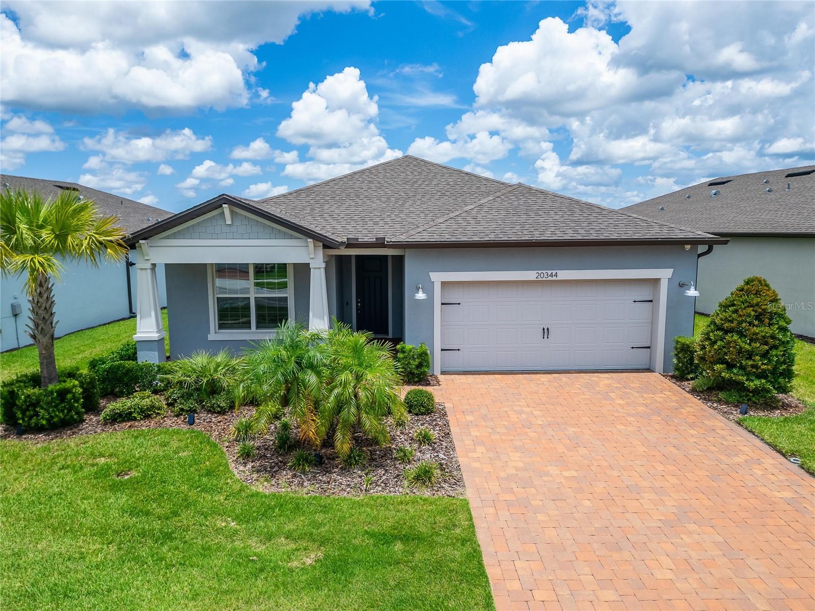 Would you enjoy living in a Vibrant 55+ gated community where you can enjoy breathtaking SUNSETS from your backyard lanai? Where you can make new friends and connect at the Resort Style 19,000 SF clubhouse? Open the front door of your new home and enter into your own little slice of Florida paradise with a water view! This popular 1889 SF "Mystique" home with tandem garage boasts an open floor plan. As you walk through the front door, you'll be welcomed by Wide Luxury Vinyl Flooring throughout the main living area and Upgraded Tile in the wet areas. The Gourmet Kitchen is equipped with an Upgraded KitchenAid Appliance Package, including GAS COOKING, QUARTZ countertops, complimentary tile backsplash, Custom White Cabinetry finished with soft-close drawers and pull-outs in cabinets. This is the perfect space for entertaining with seating along the HUGE Quartz topped island adorned with pendant lighting. The Oversized pantry is the perfect place to hide those small appliances and keep the kitchen well stocked and looking neat & tidy. All appliances including washer and dryer are included! Walk into the Dining Area that can accommodate a table and chairs for six or even eight, and is fitted with Remote Controlled Sunshades. When open, you can gaze out over your backyard, watching birds and occasionally spotting deer drinking water from the pond. The Great Room, complete with a Tray Ceiling & Crown Molding, is a dream for interior designers. Time to head outside from the Great Room into the Extended Enclosed Lanai that offers unobstructed views, thanks to the upgraded Panoramic Screens. The Primary Bedroom and Ensuite Bathroom are tucked away at the back of the home providing ultimate privacy when hosting overnight guests. The Primary En-Suite features an upgraded Walk-in shower with dual shower heads, custom upgraded tile, a linen closet, and private water closet. The Secondary Bedroom, Guest bathroom, and Flex space are conveniently located at the front of the home. Your new house is secured with an Alarm System, complete with cameras on the front door, doorbell, driveway, backyard, and lanai area for home monitoring while you are away. Sliding Plantation Shutters custom fit all the windows. Hurricane shutters included. Bonus - the Tandem garage with epoxy flooring provides plenty of room for two cars AND a golf cart, motorcycle, or additional storage. Should you desire an additional bedroom later, this part of the garage has already been vented for air conditioning/heating. Your low monthly HOA fee includes the use and maintenance of state-of-the-art amenities, landscaping within the common areas inside of the gates and maintenance of the landscape on your home site. In addition your monthly fee includes a broad internet and cable TV package. In this gated community the clubhouse features a fitness center, ball room, multi-purpose rooms, clubs, planned activities, a bistro and more. Outdoors you will enjoy bocce ball, pickle ball, tennis, a resort style zero entry heated pool, additional walking resistance pool, spa, community garden, amphitheater and even a dog park. Feel free to jump on your golf cart and drive to the Meridian Clubhouse, where a full time activities director will keep you as busy as you want. DWB is located just a short distance from shopping, restaurants, the Premium Outlet Mall and Tampa’s International airport. Please note that one person living in each home must be at least 55 years of age.